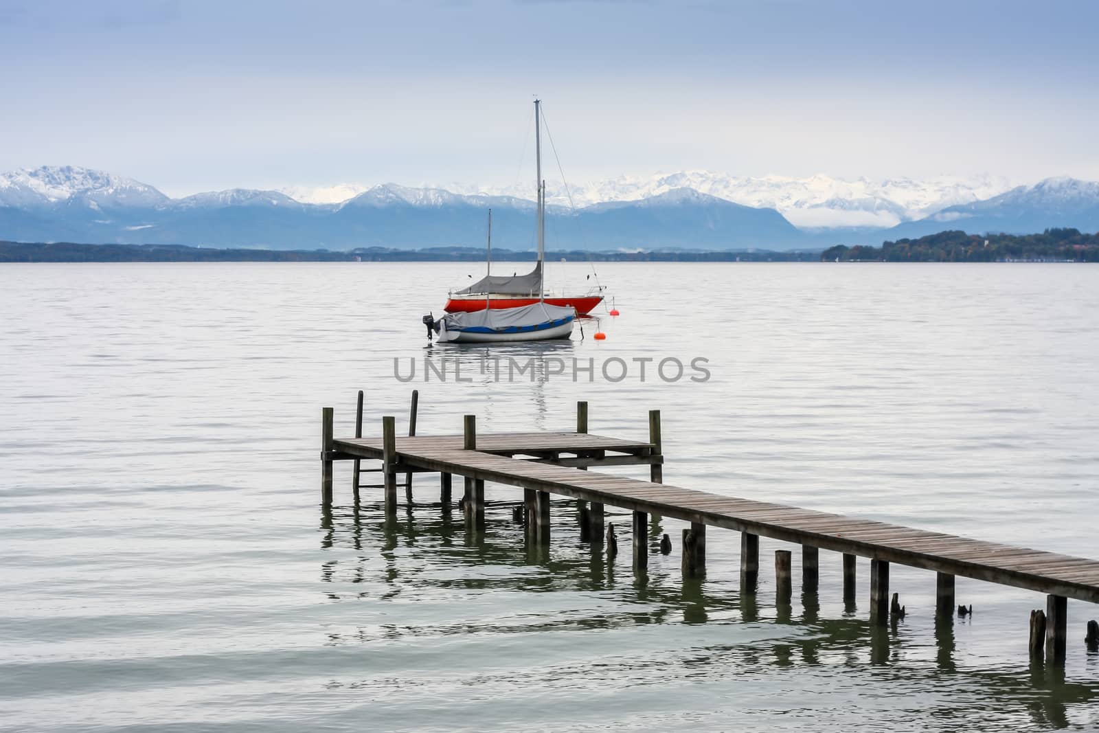 An image of Starnberg lake jetty and boats Alps in winter season