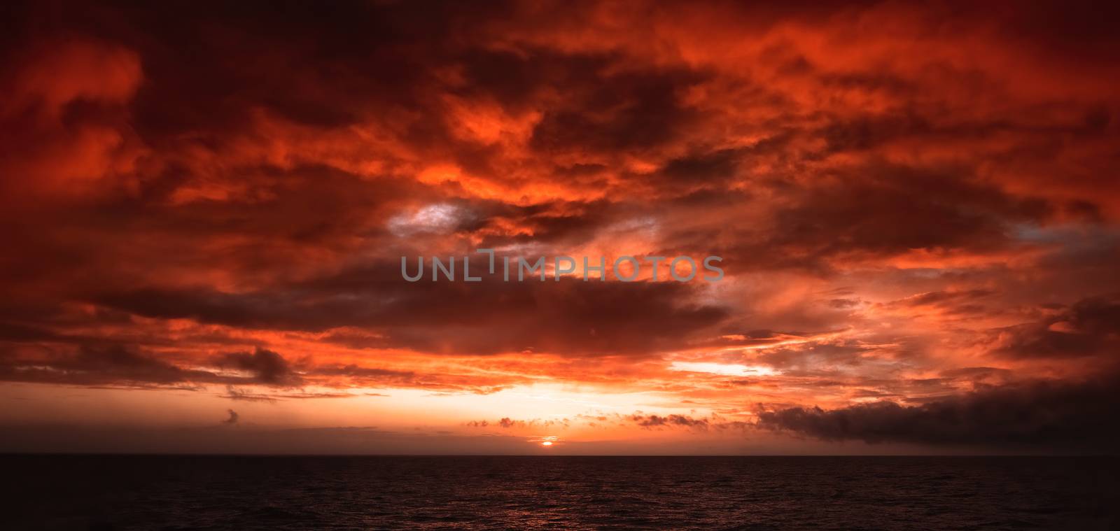 Dramatic Fiery Sunset With Orange And Red Clouds Over The Ocean