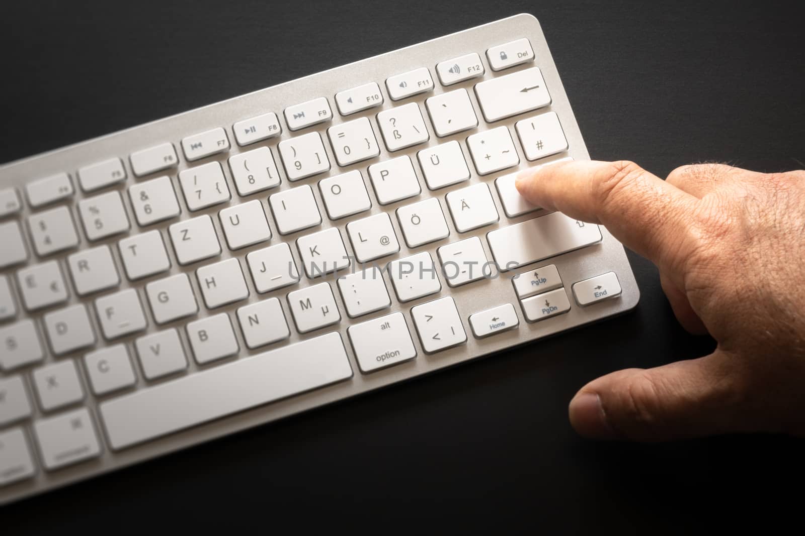 An image of a typical computer keyboard with finger on enter