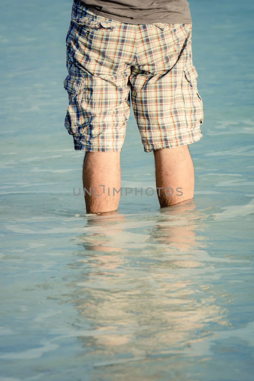 man standing in the sea water by magann