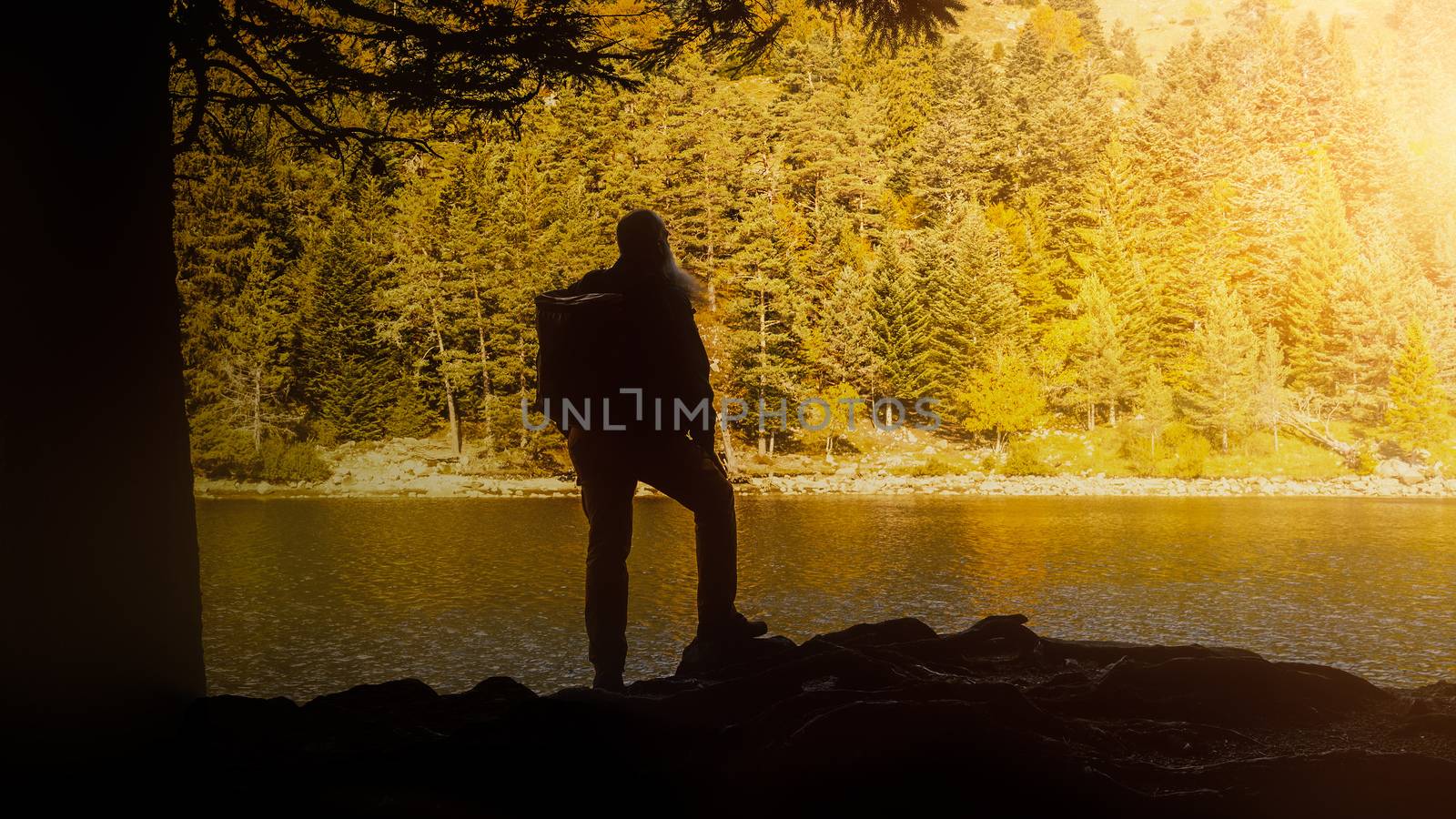 An image of a silhouette of a hiker at autumnal lake