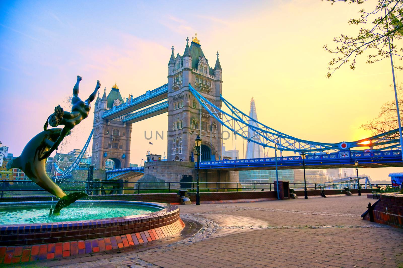 London, United Kingdom - April 17, 2019 : View of Tower Bridge on the River Thames with the Girl with Dolphin fountain, created by David Wynne in 1973.