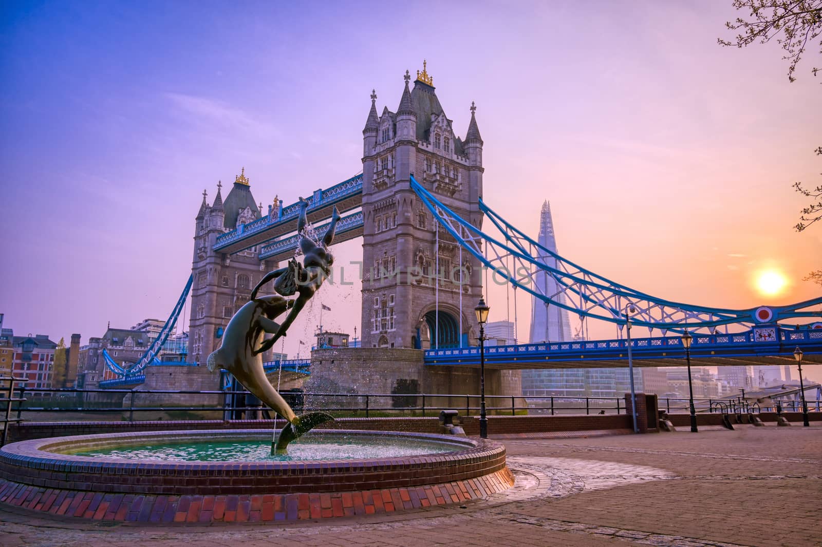 London, United Kingdom - April 17, 2019 : View of Tower Bridge on the River Thames with the Girl with Dolphin fountain, created by David Wynne in 1973.