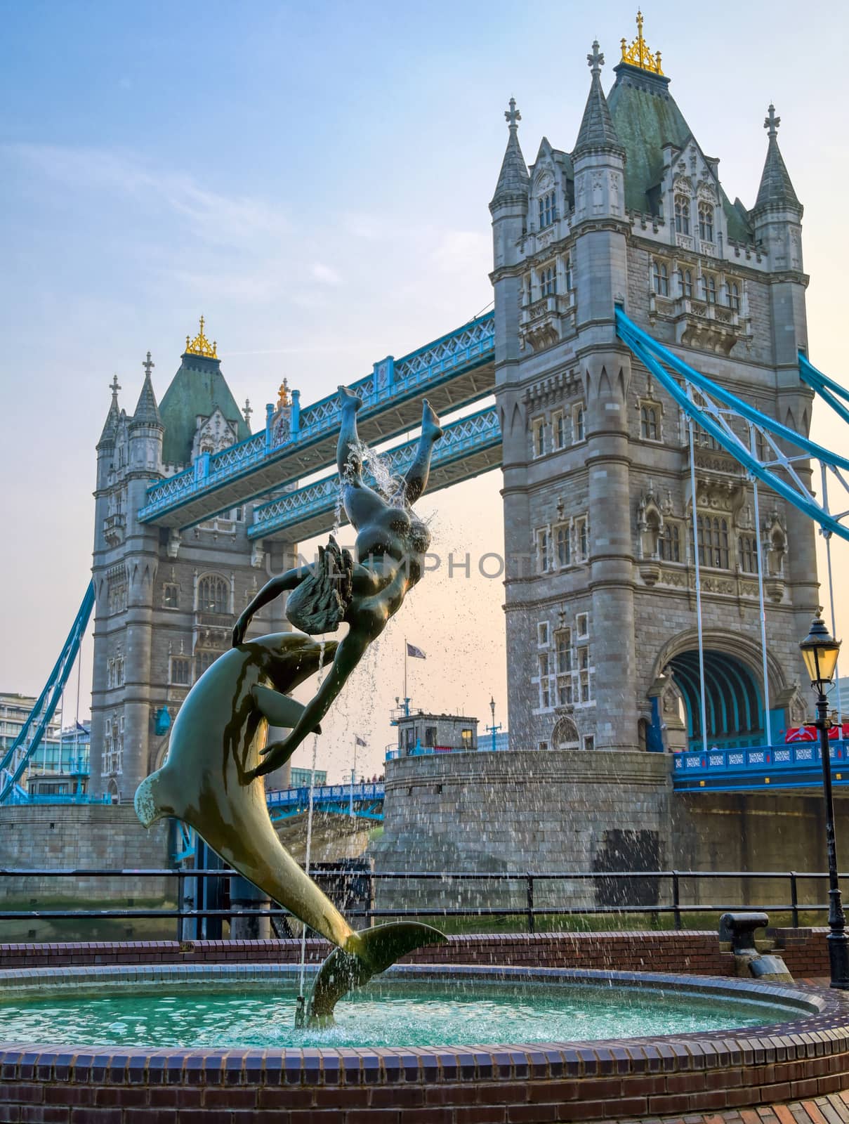 London, United Kingdom - April 17, 2019 : View of Tower Bridge on the River Thames with the Girl with Dolphin fountain, created by David Wynne in 1973.