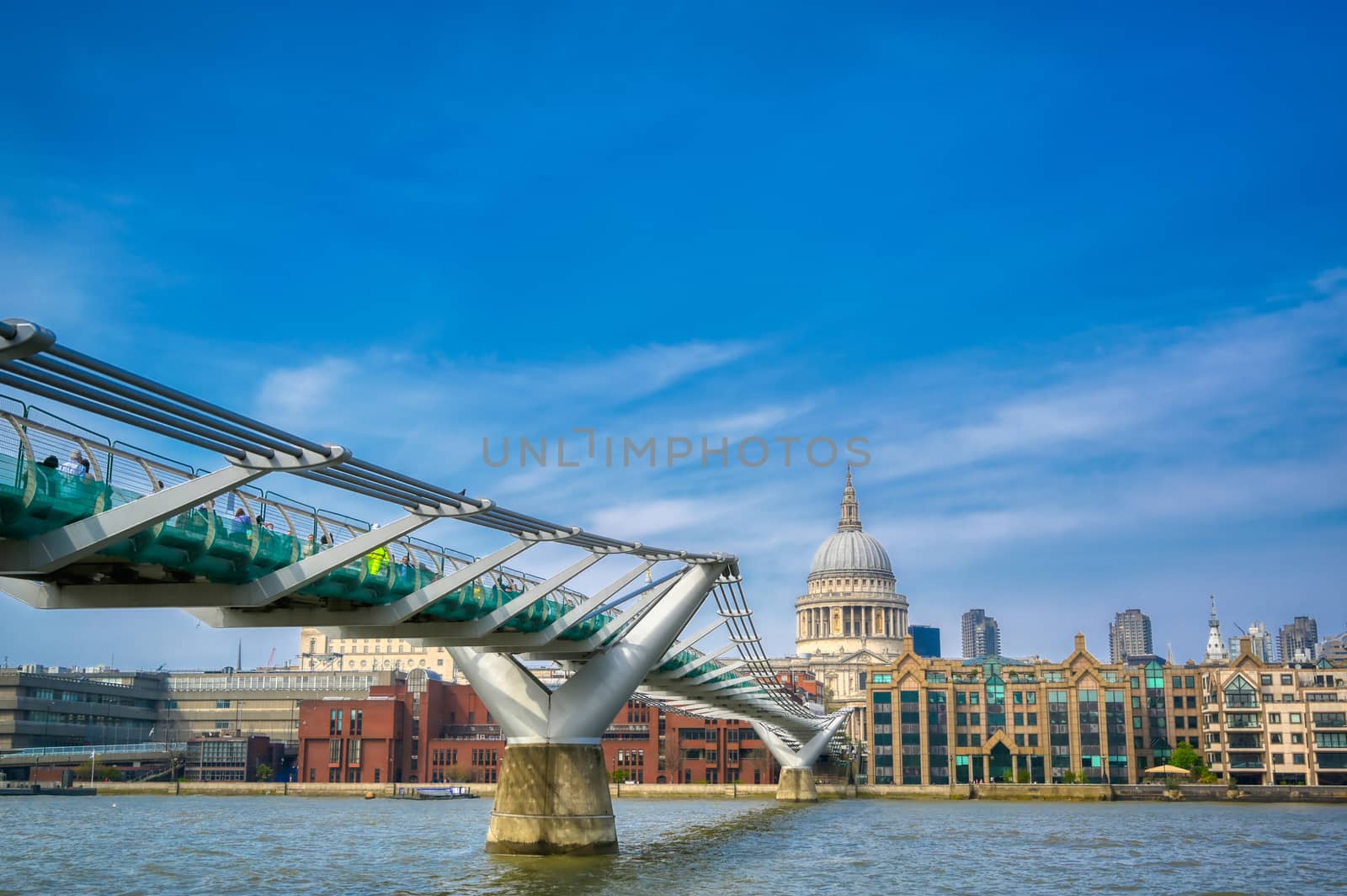 London, United Kingdom - April 18, 2019 - St. Paul's Cathedral across Millennium Bridge and the River Thames in London, UK.