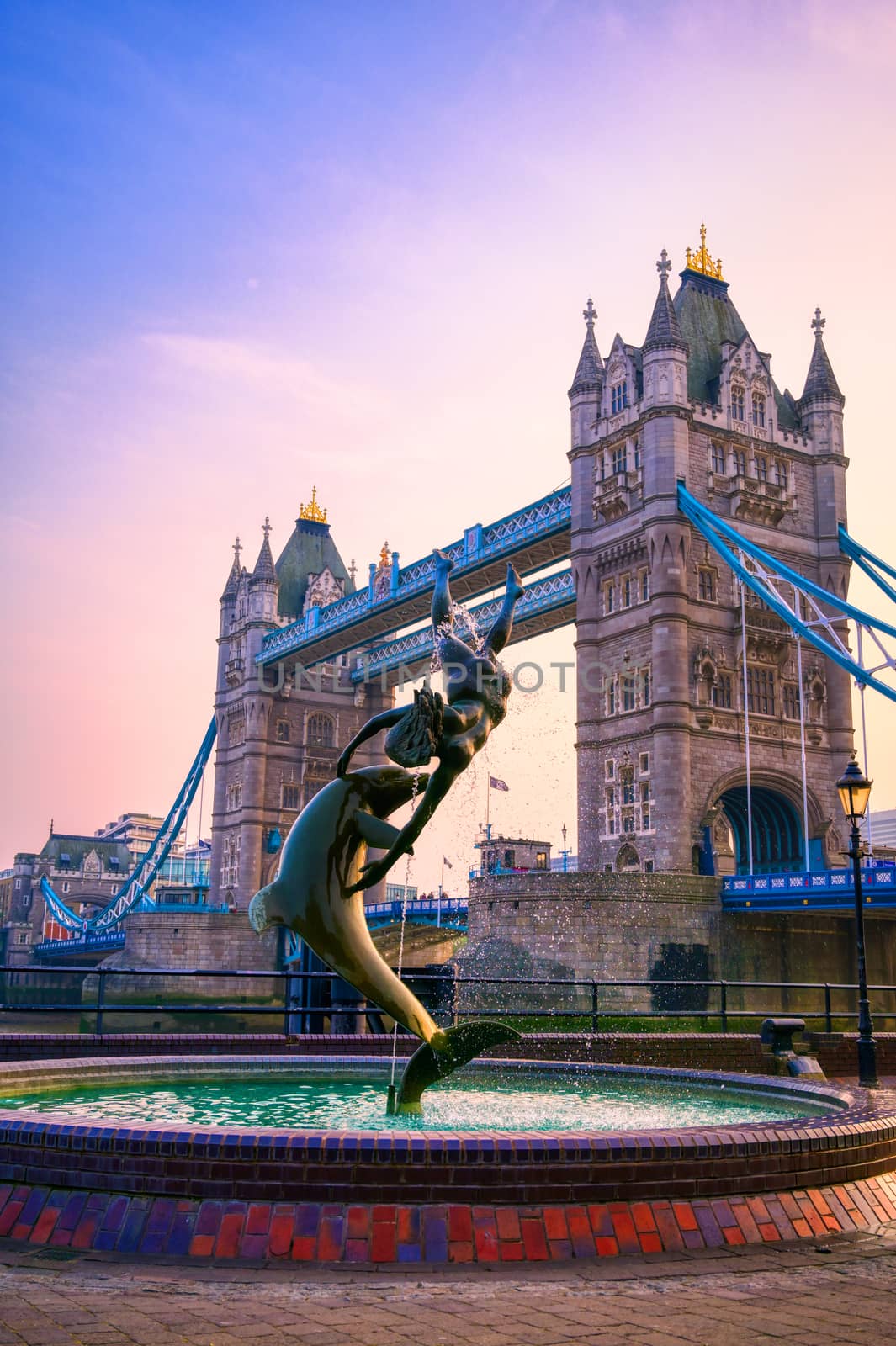 London, United Kingdom - April 17, 2019 : View of Tower Bridge on the River Thames with the Girl with Dolphin fountain, created by David Wynne in 1973.