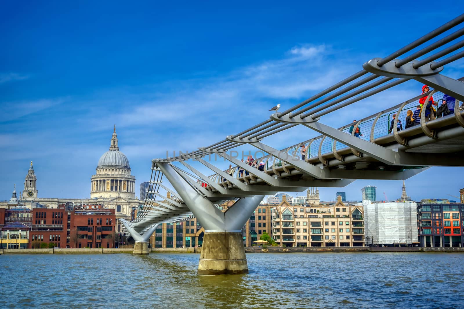 London, United Kingdom - April 18, 2019 - St. Paul's Cathedral across Millennium Bridge and the River Thames in London, UK.