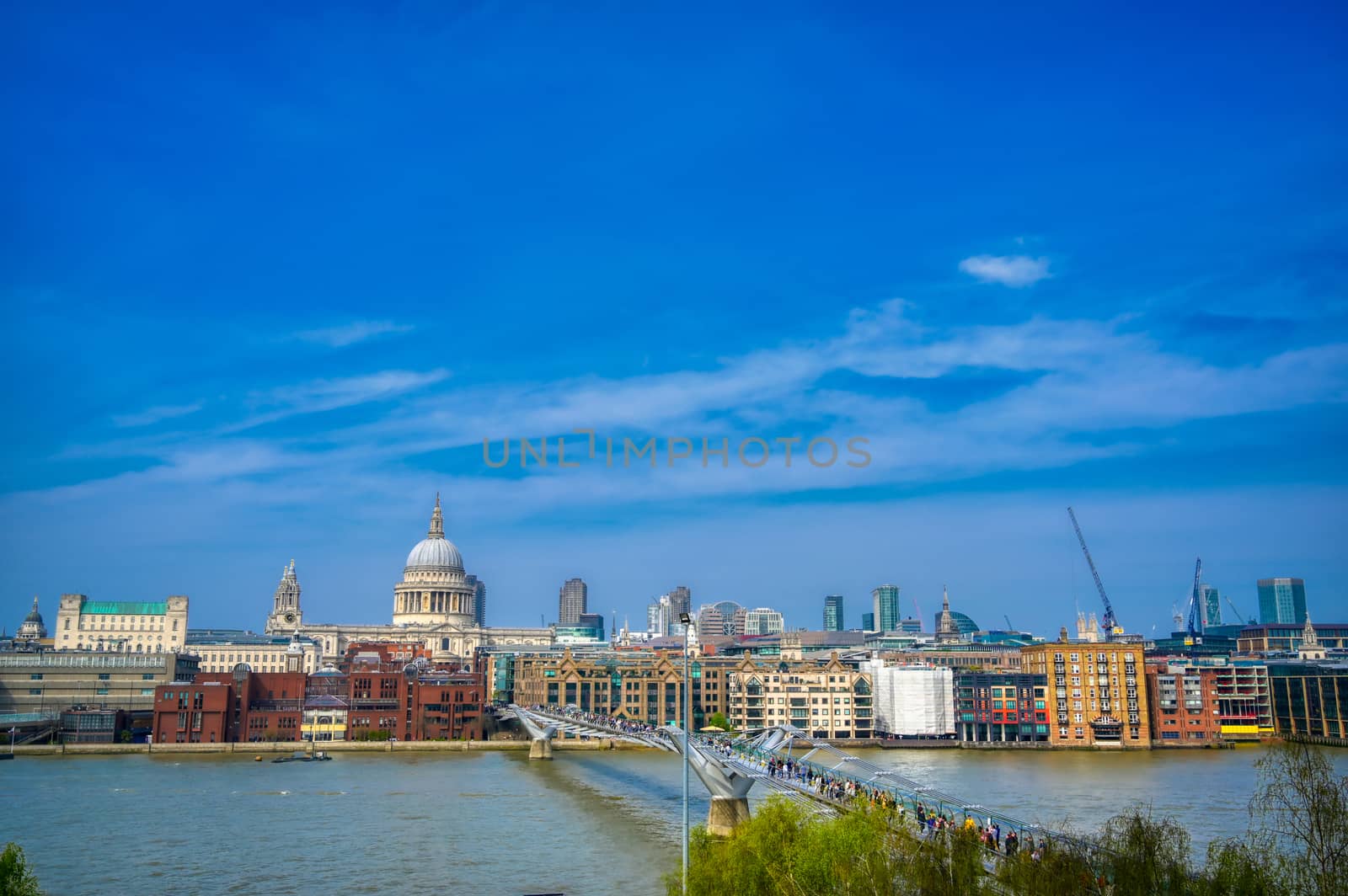 London, United Kingdom - April 18, 2019 - St. Paul's Cathedral across Millennium Bridge and the River Thames in London, UK.