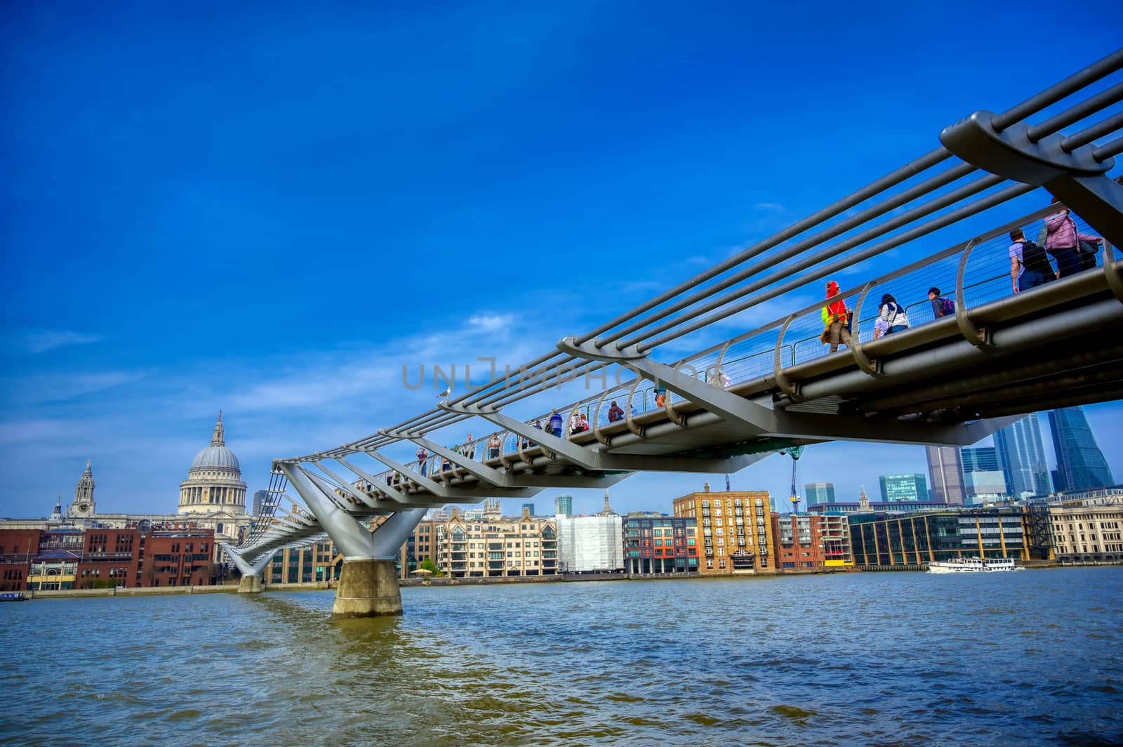 London, United Kingdom - April 18, 2019 - St. Paul's Cathedral across Millennium Bridge and the River Thames in London, UK.