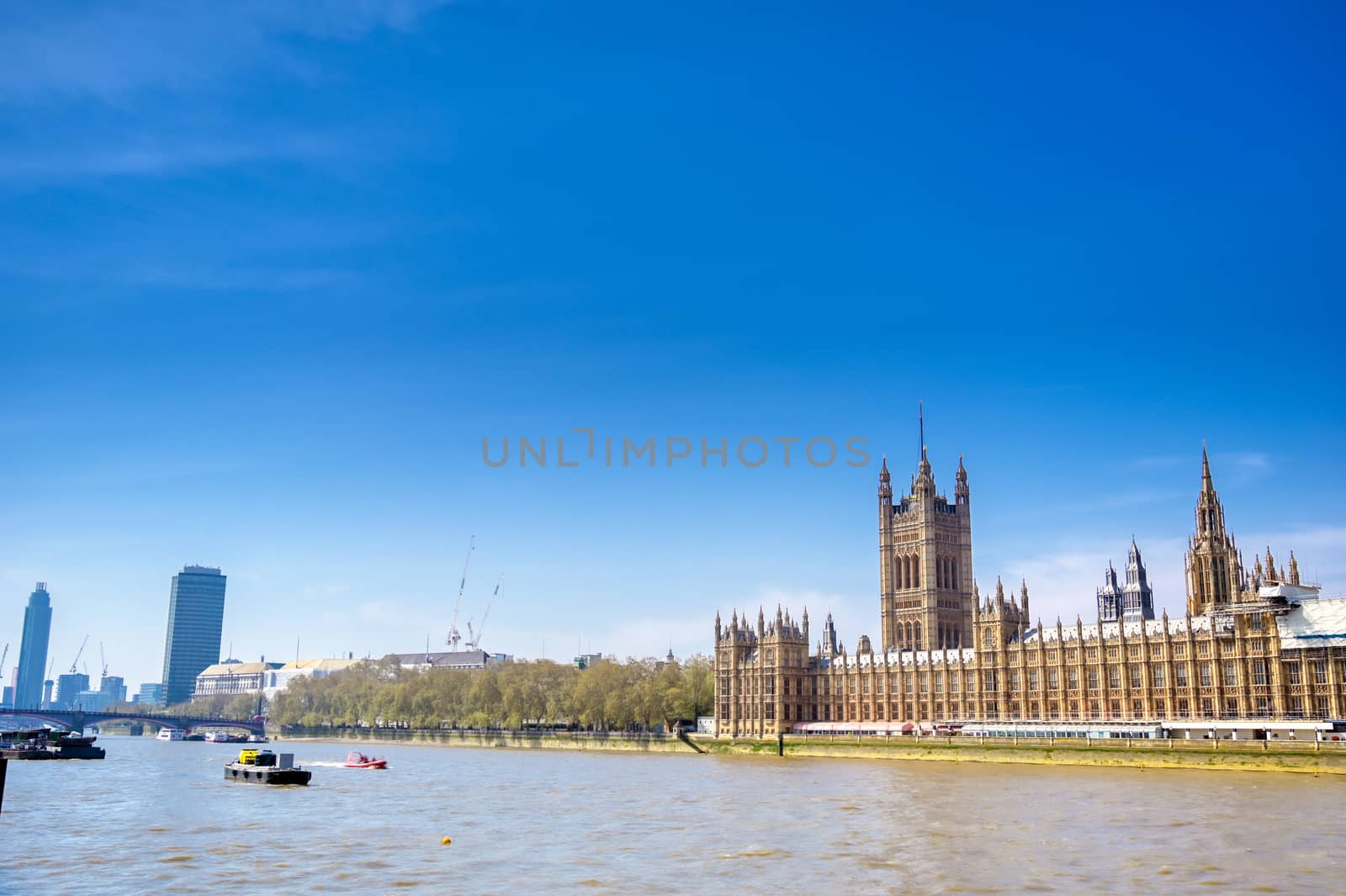 British Parliament along the River Thames on a sunny day in London, UK.