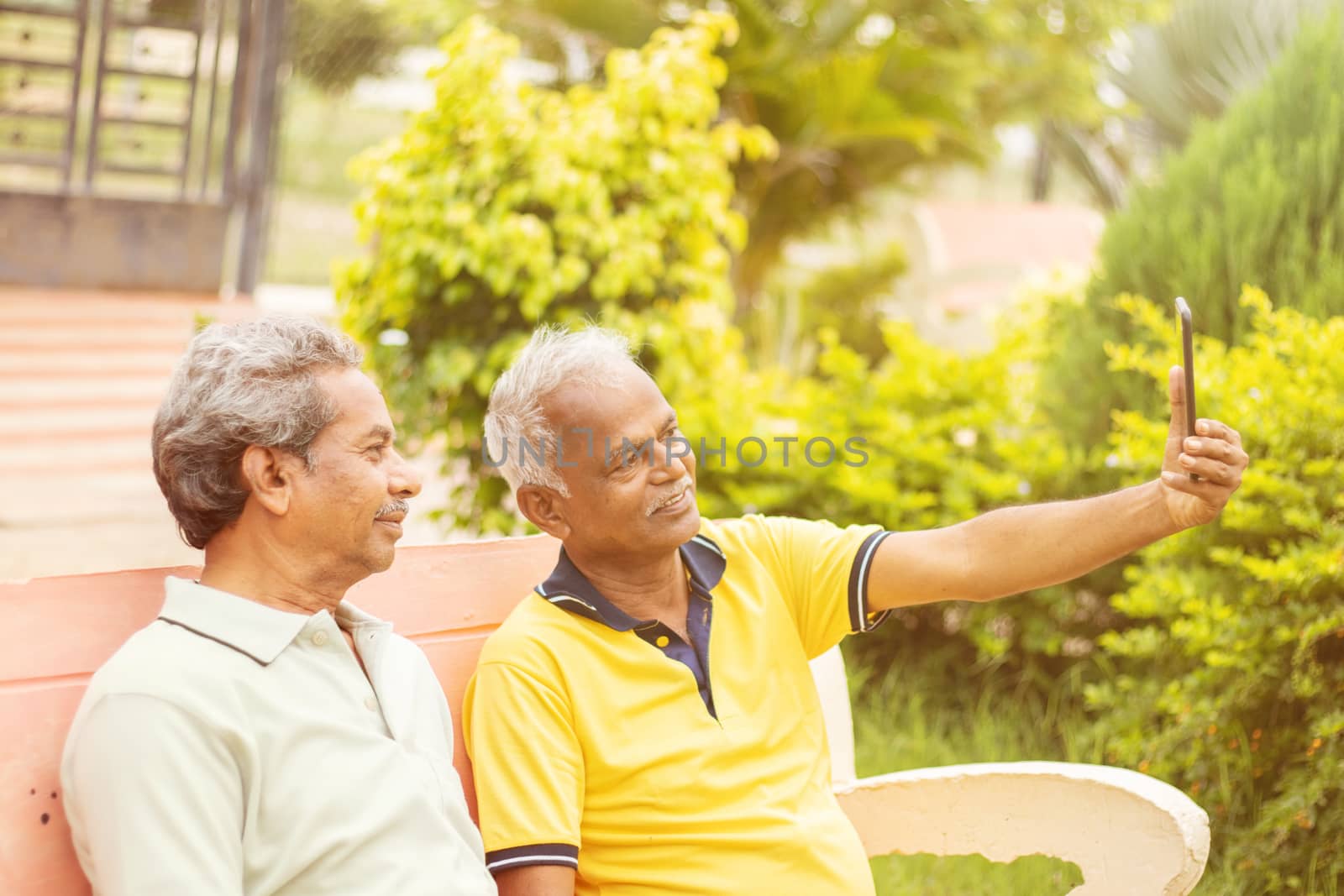 Two Senior happy friends taking a selfie at Park, Outdoor - Elderly men healthy lifestyle - Concept of active and fun elderly people using new technologies.