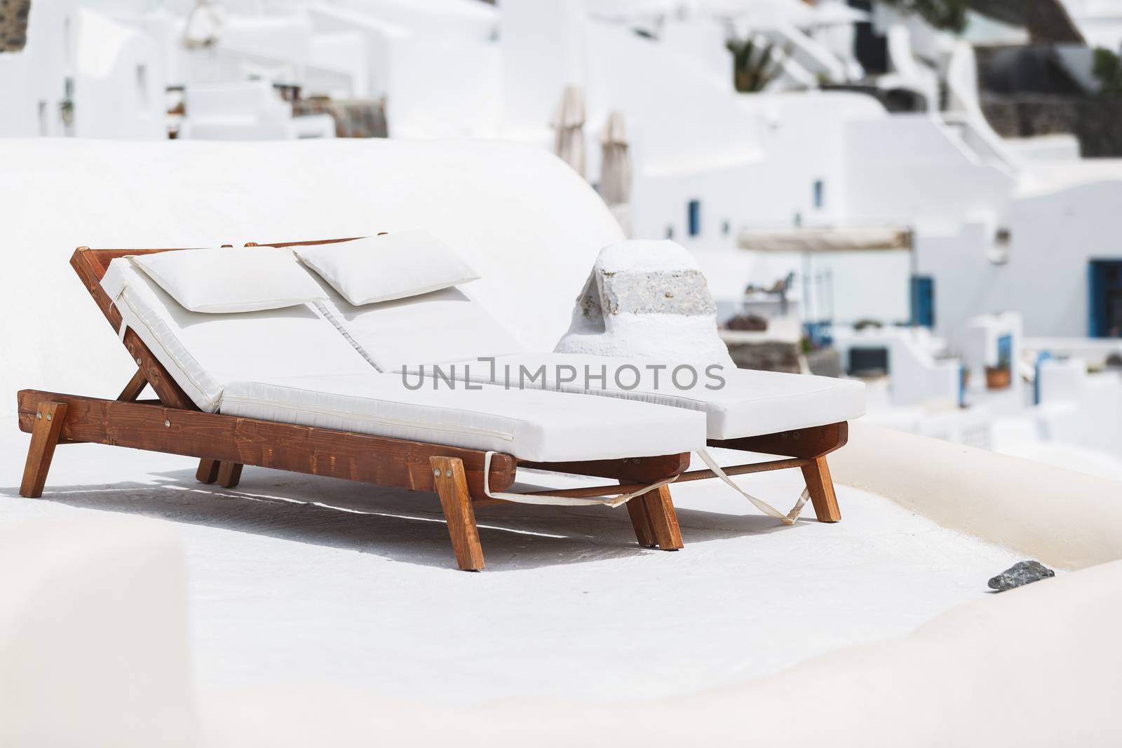 Two sun beds on traditional terrace. Santorini island, Greece
