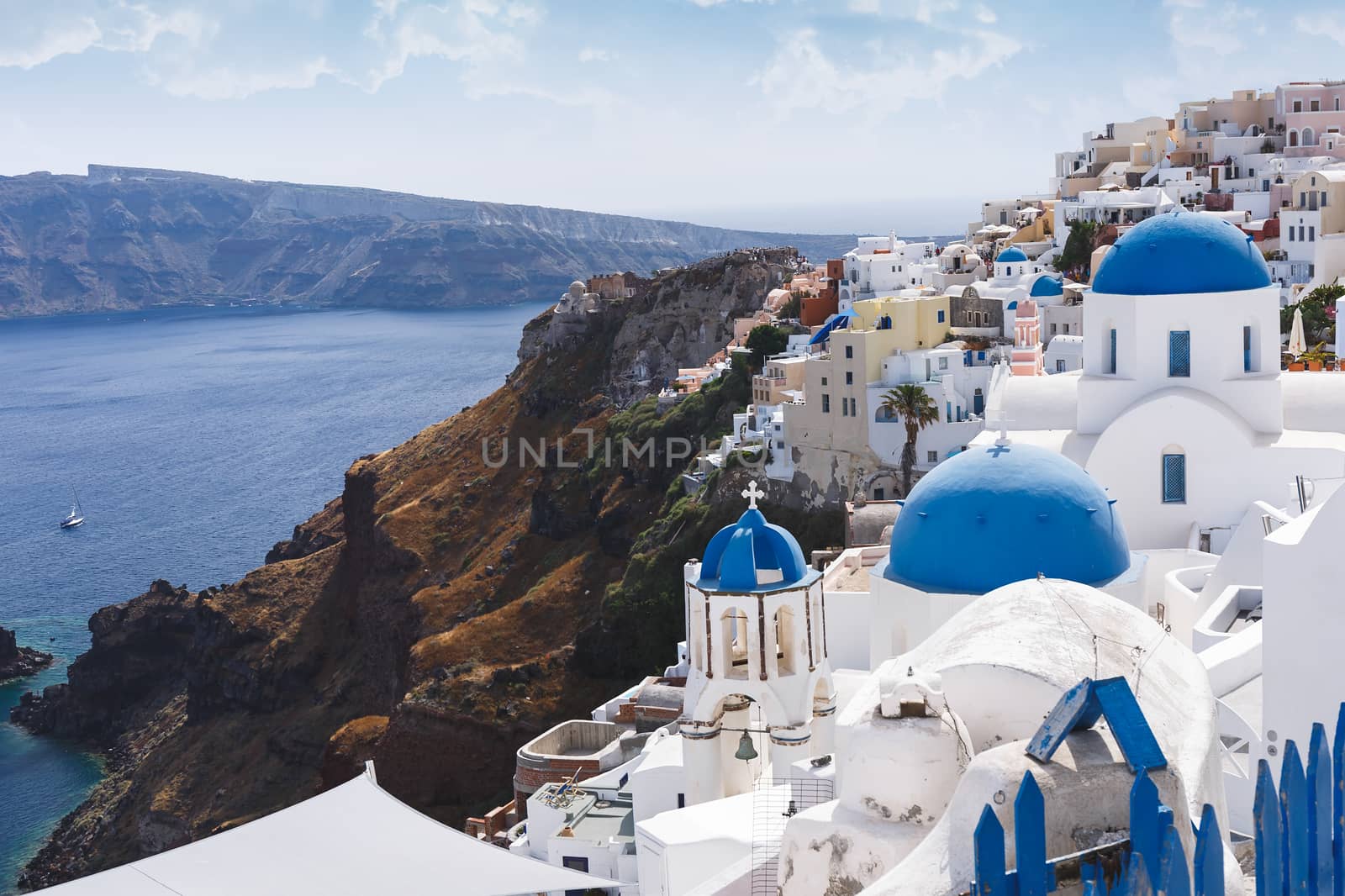 Blue domes and bell tower of churches in Oia, Santorini, Greece.  The edge of the caldera with the blue domes of churches in the foreground, selective focus by Slast20