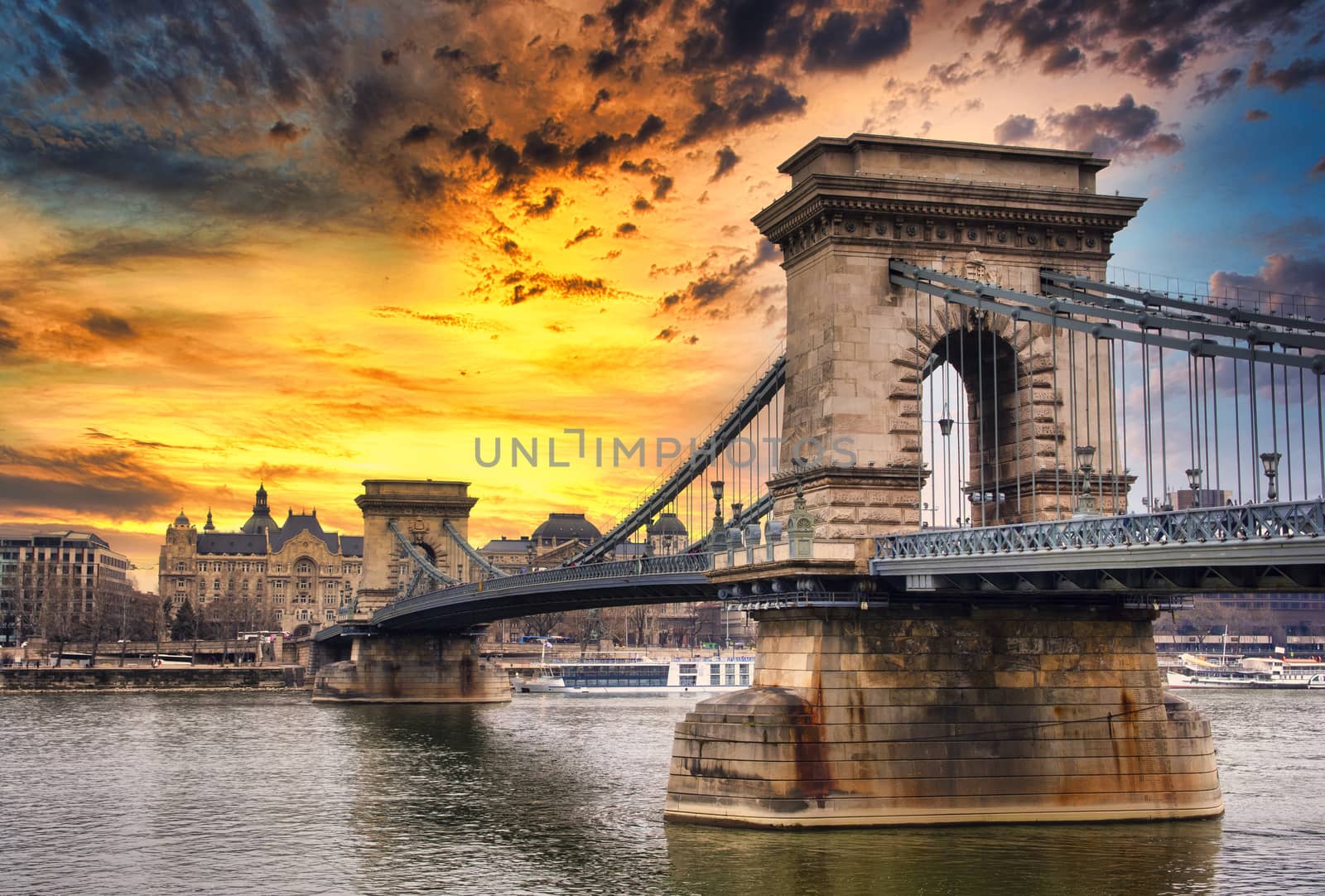 Chain bridge on Danube river in Budapest city in Hungary. Urban landscape panorama with old buildings at sunset.