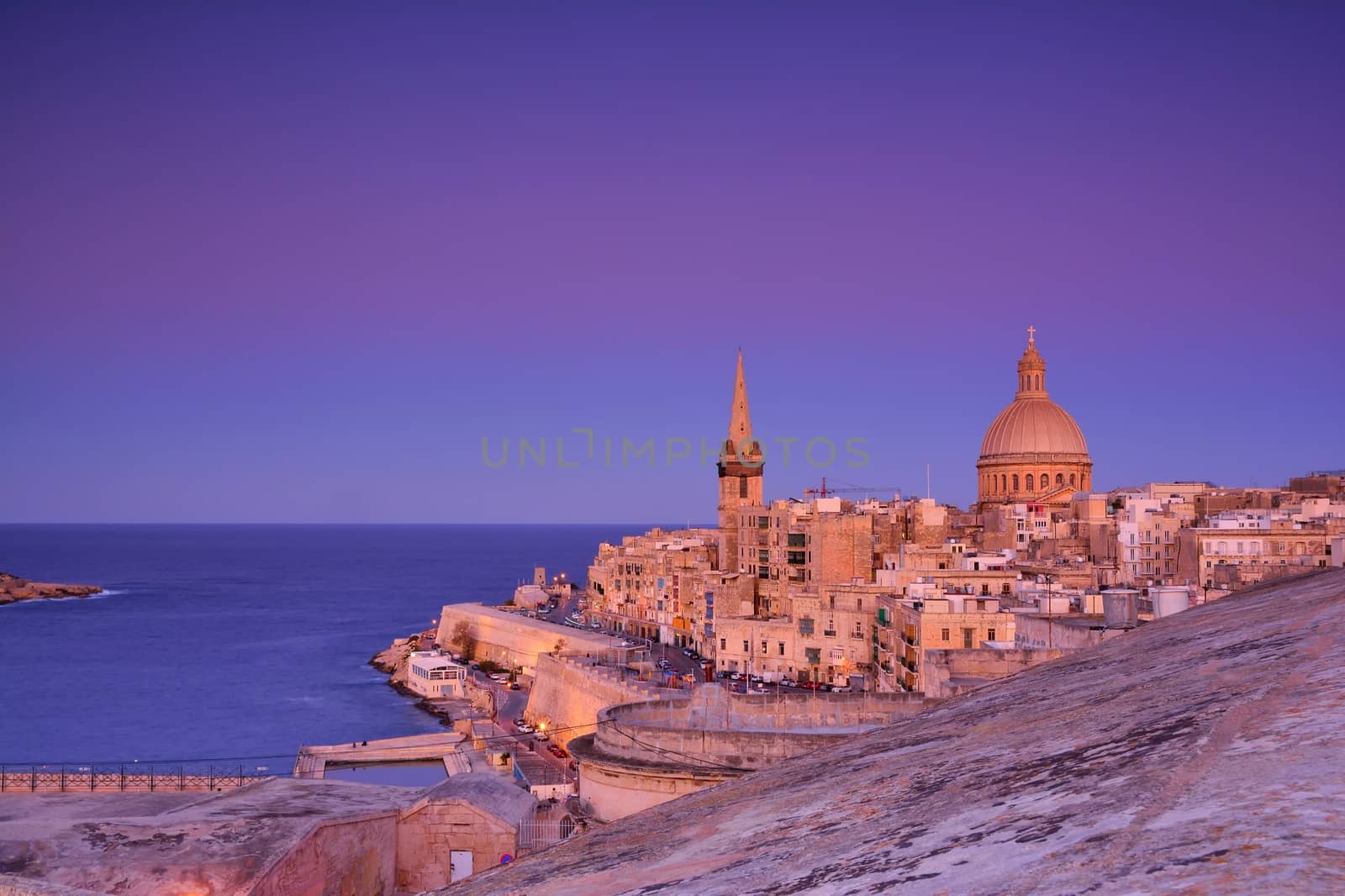 View from above of the golden dome of church and roofs with church of Our Lady of Mount Carmel and St. Paul's Cathedral in Valletta, Malta.
