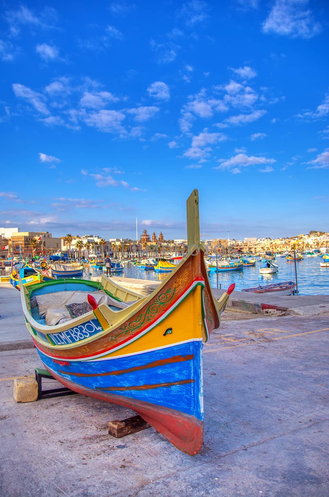 Marsaxlokk, Malta - January 10, 2020: Beautiful view of the traditional eyed colorful boats Luzzu in the Harbor of Mediterranean fishing village Marsaxlokk, Malta