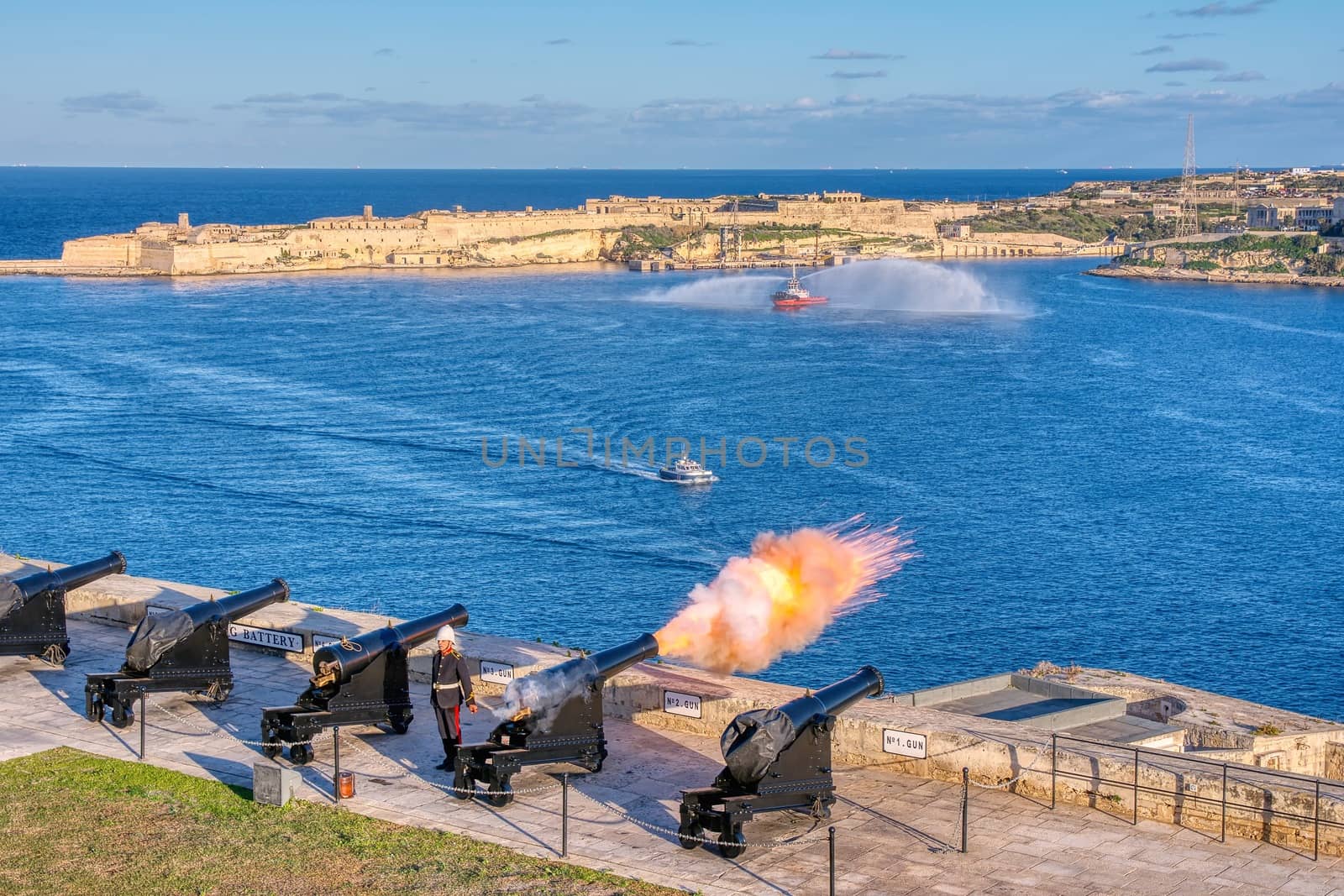 Valletta, Malta - January 9, 2020: Shot from cannon at noon in Saluting Battery at Upper Barrakka Gardens, with Birgu on the background, Valletta, Malta.