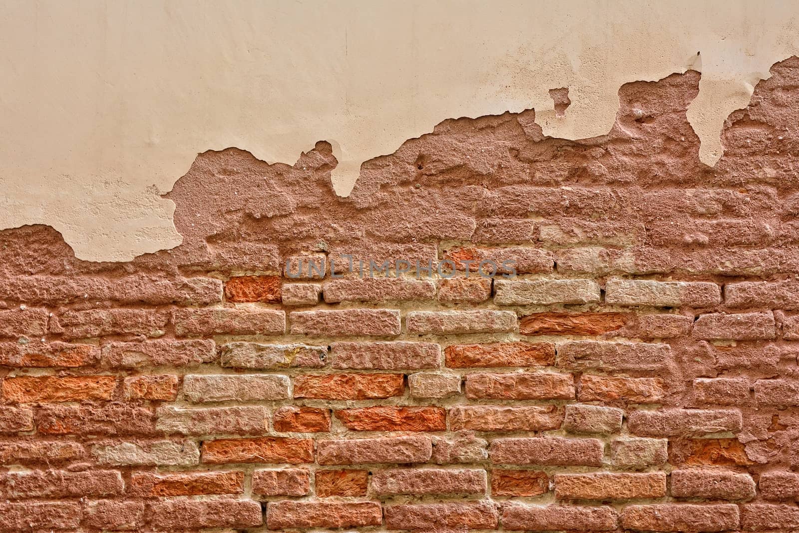 Old brick wall with peeling plaster, old background.