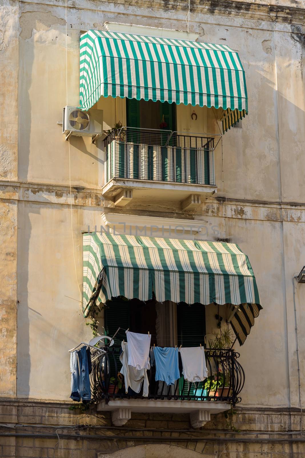 Traditional balconies with awnings and hanging laundry in Bari, Apulia, Italy