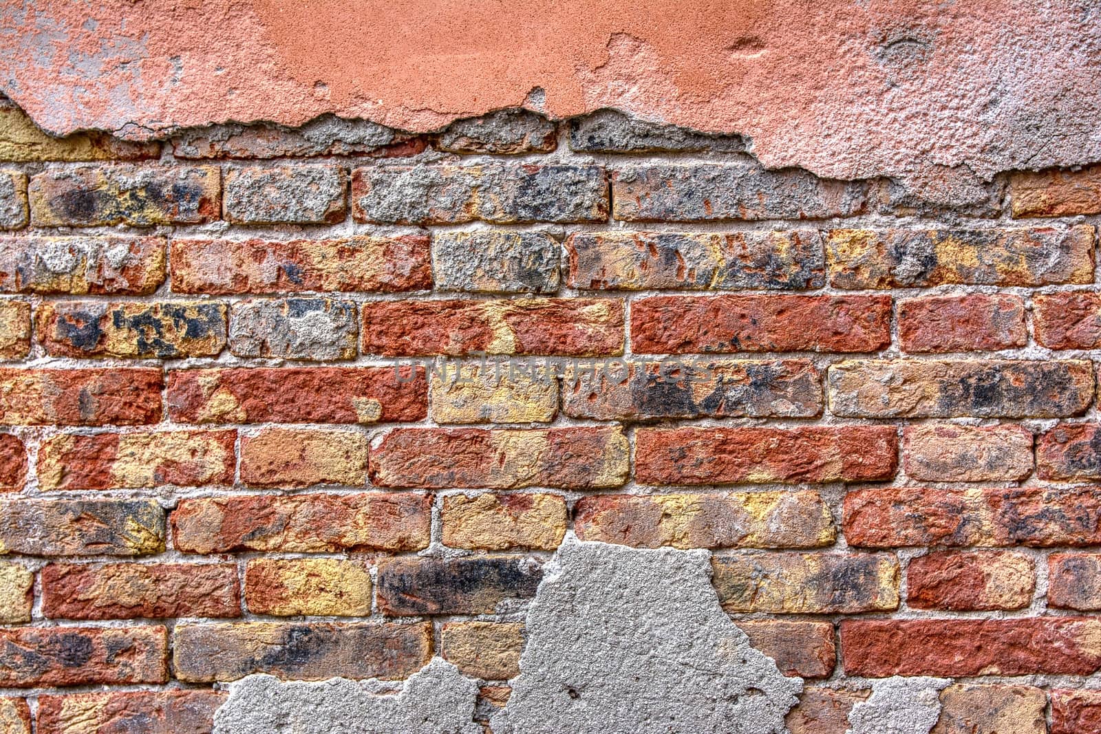 Old brick wall with peeling plaster, grunge background.