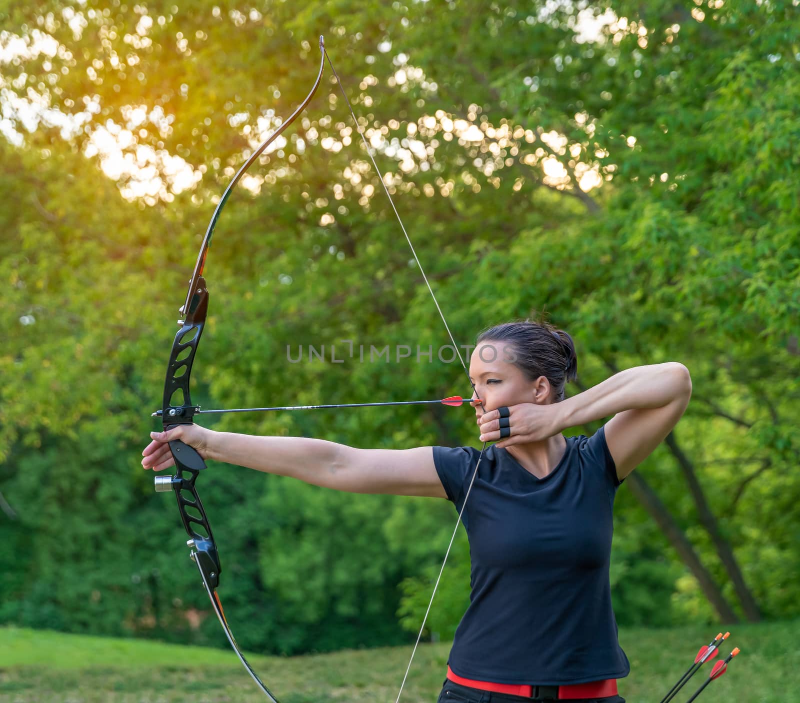 attractive sports woman in archery, arrows and bow in action by Edophoto