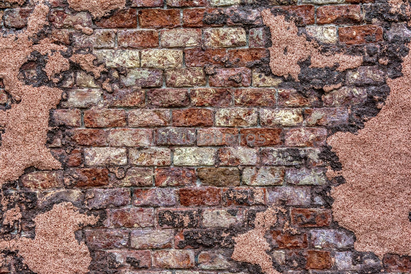 Old brick wall with peeling plaster, grunge background.