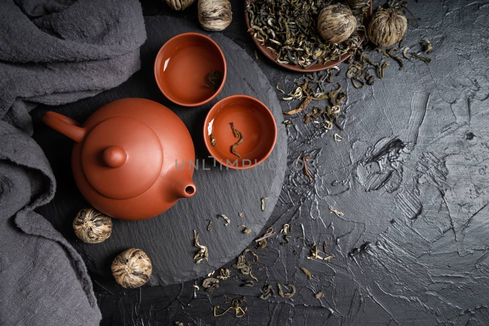 Asian teapot and green tea on slate plate top view flat lay with copy space