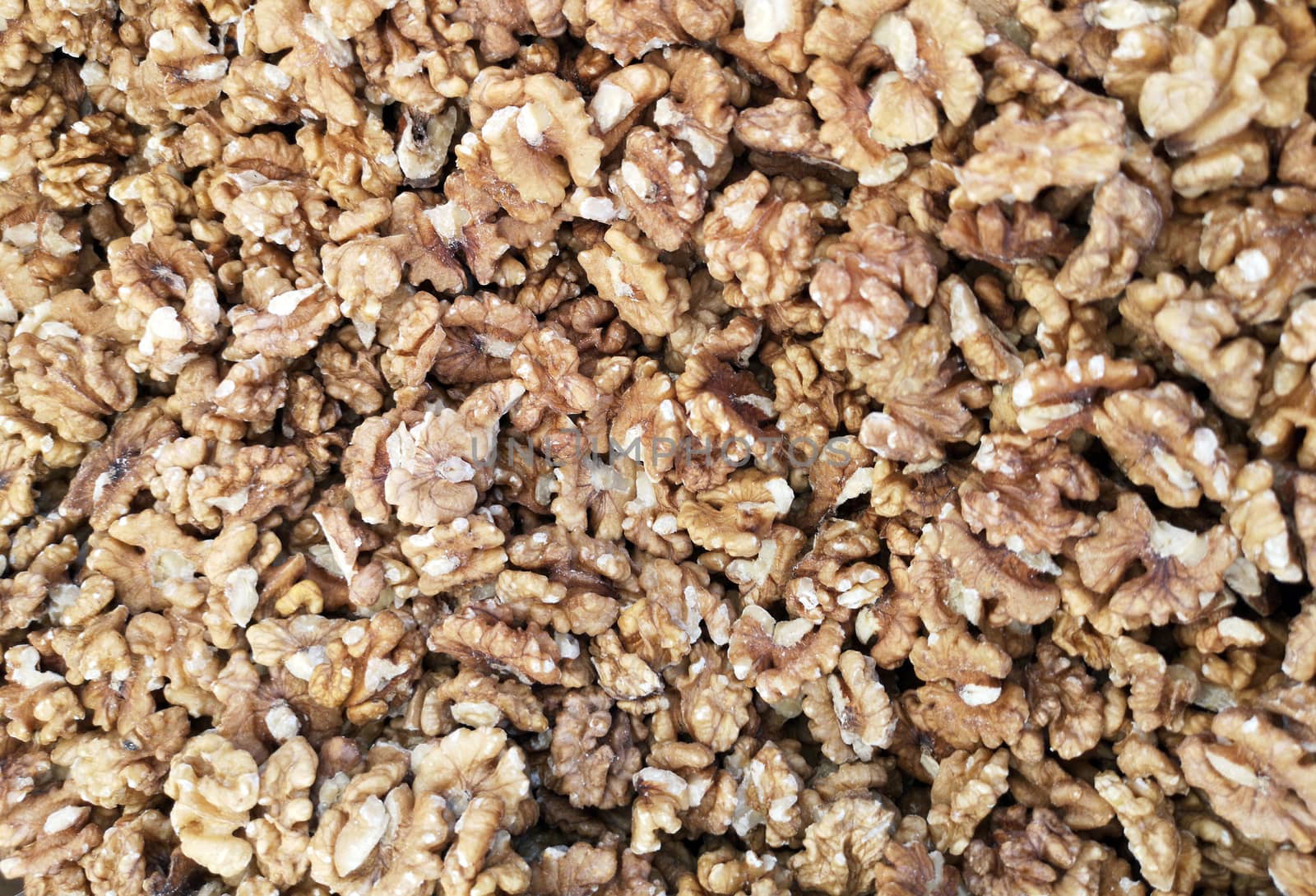 Peeled walnuts as background. Closeup of big shelled walnuts pile