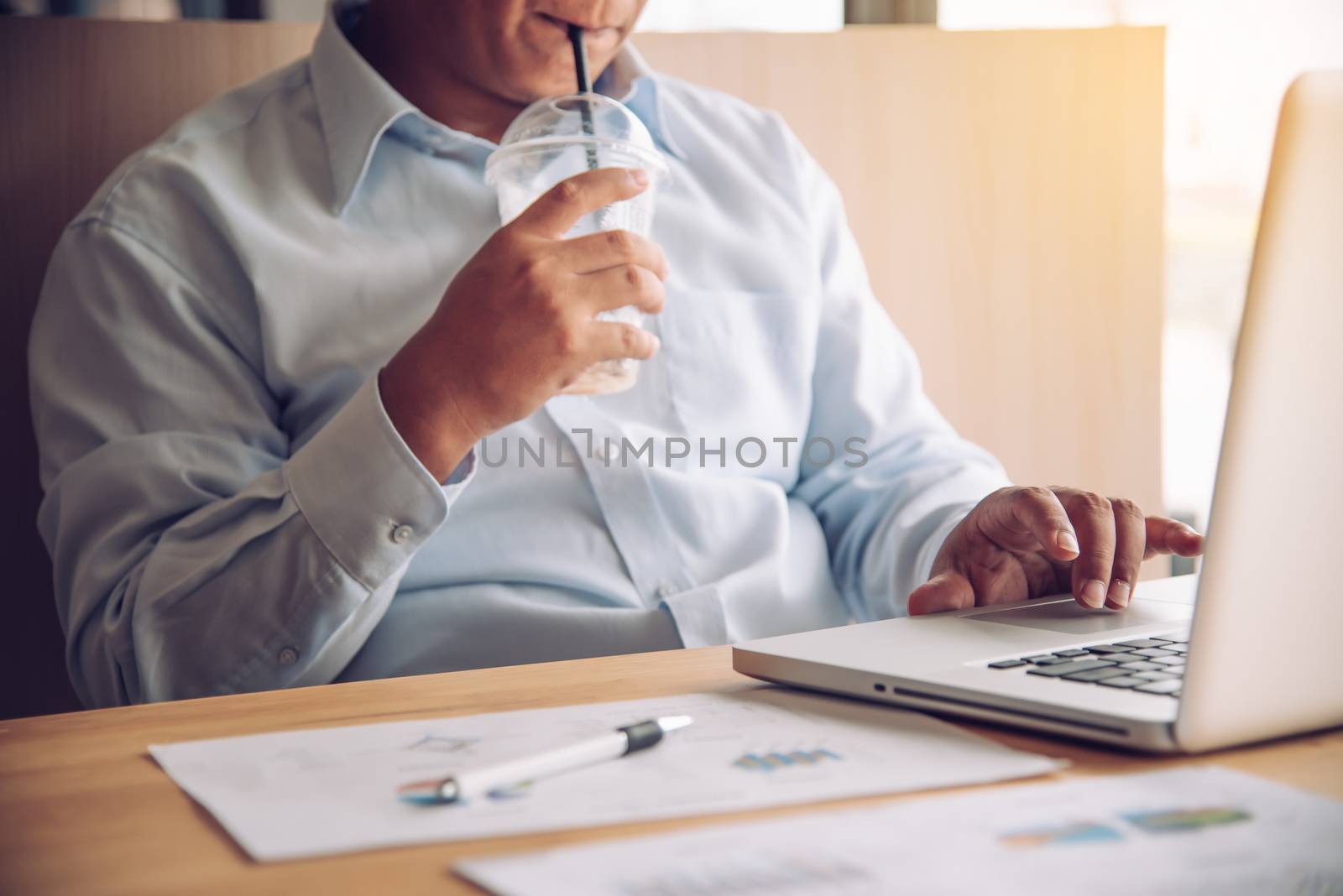 Young man drinking coffee while working on laptop