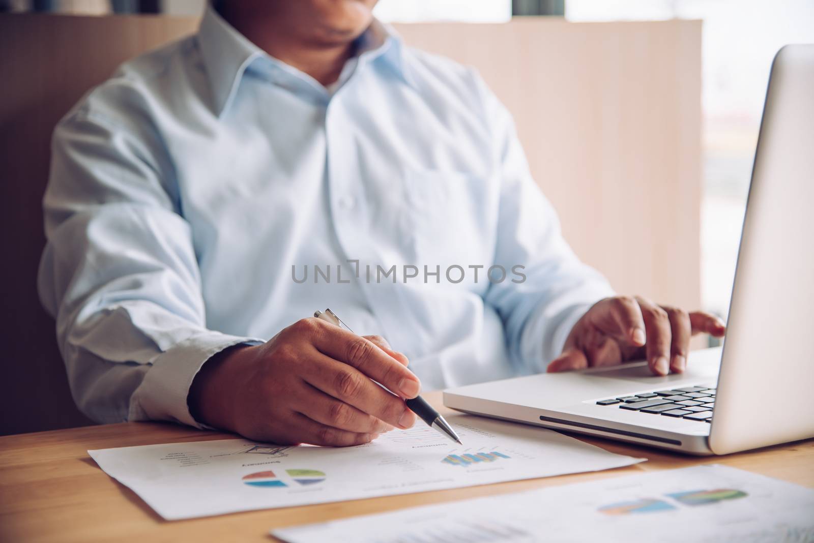 businessman working with laptop in open space office by photobyphotoboy