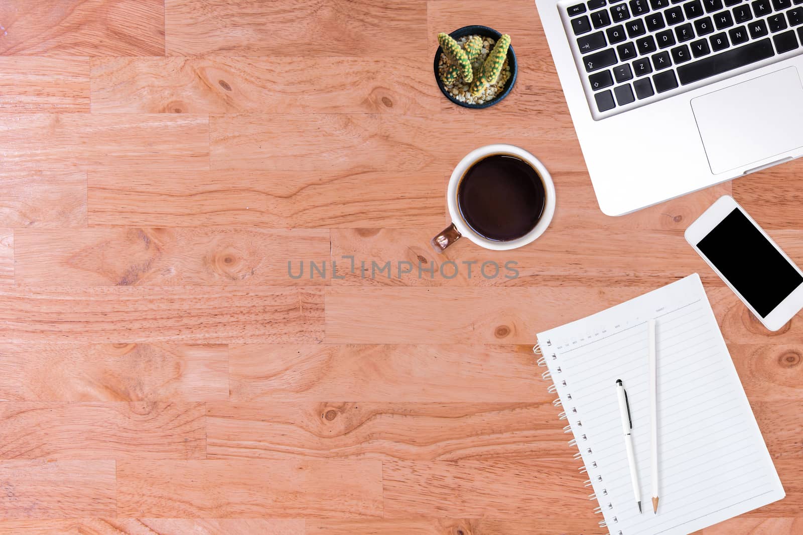 Modern office desk wooden table with laptop computer, smartphone, notebook, pen, pencil, and cup of coffee. Working desk table concept.Top view with copy space, flat lay.