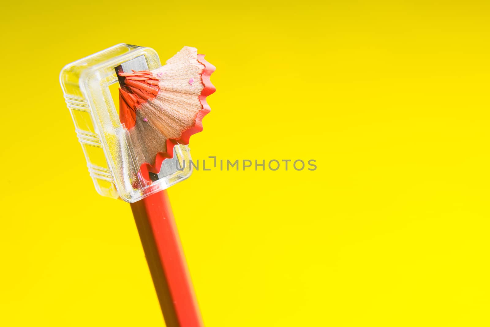 Sharpened red pencil isolated on yellow background. by Bubbers