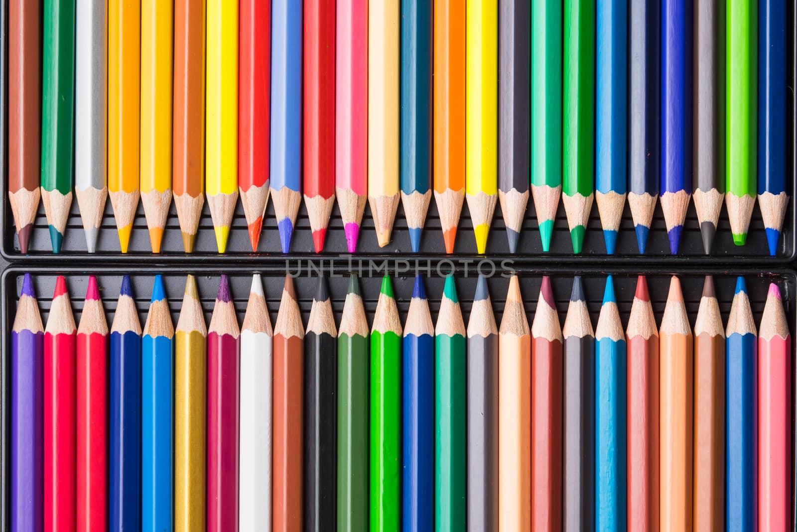 Color Pencils with plastic case isolated on Black Background close up. Colored style view top flat lay with free copy space for design or text. Back to school theme