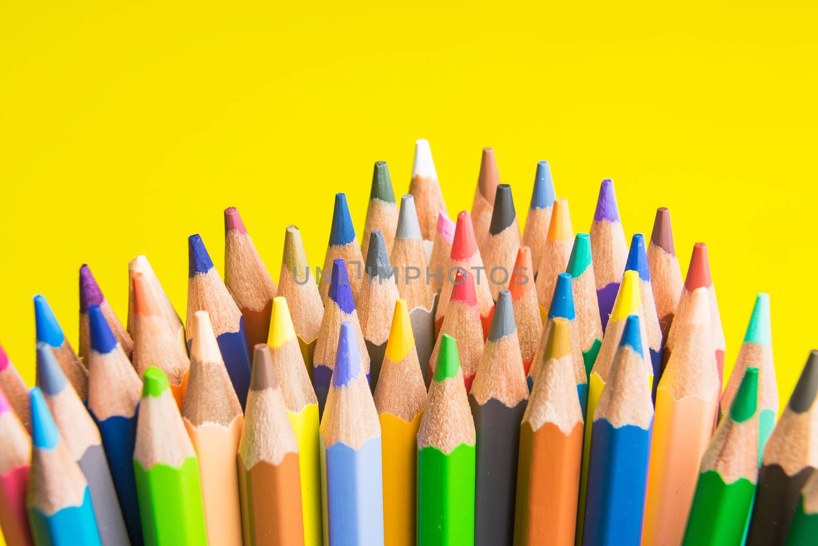 Back to school set multicolored pencils colorful making forms side view on a yellow backround