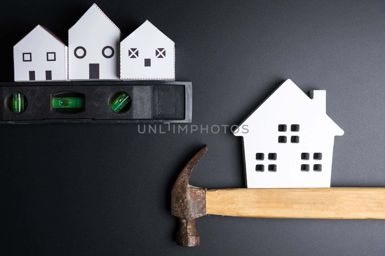 White house toy and construction tools on black background with copy space.Real estate concept, New house concept, Finance loan business concept, Repair maintenance concept