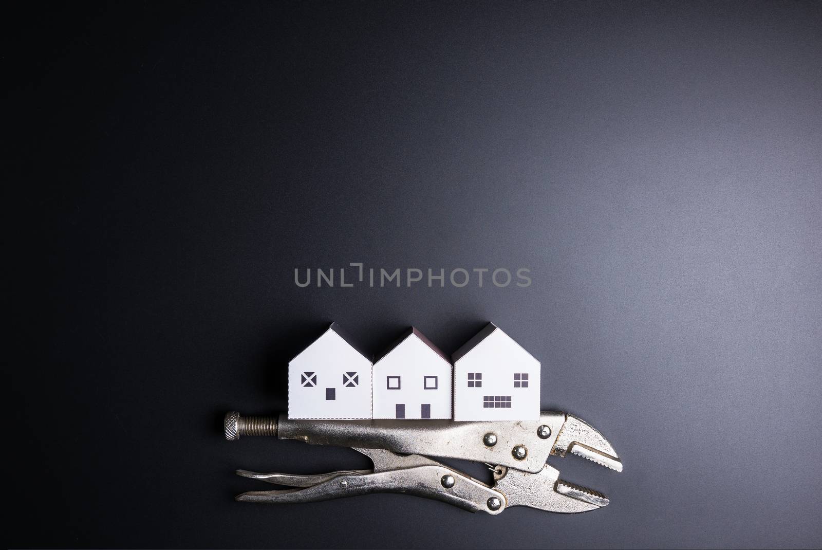 White house toy and construction tools on black background with copy space.Real estate concept, New house concept, Finance loan business concept, Repair maintenance concept