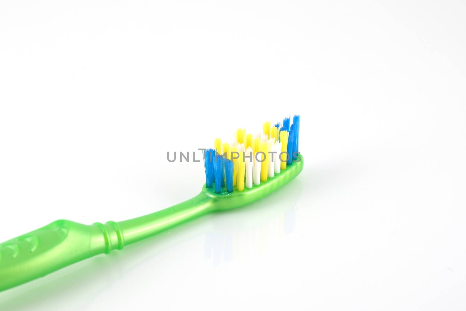 Tooth-brush with green handle over white by sergpet
