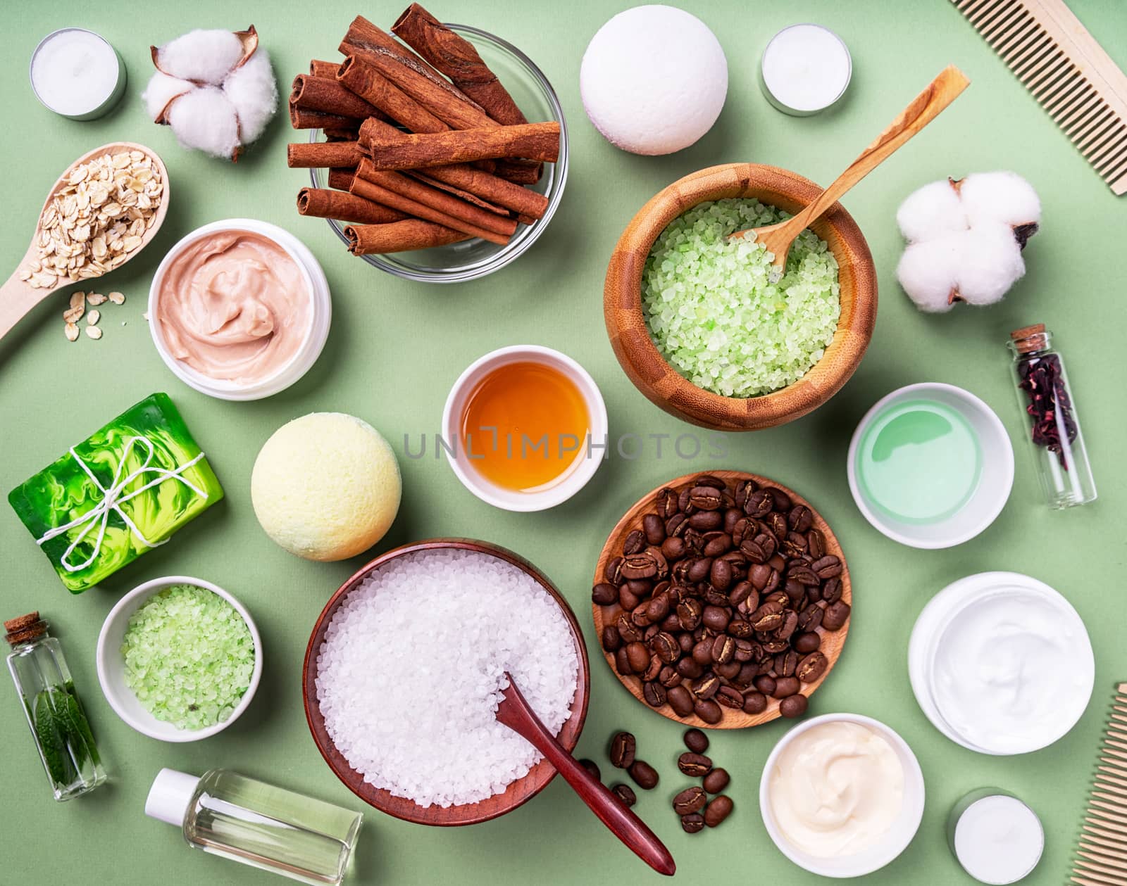 Natural cosmetics and spa ingredients top view on green background