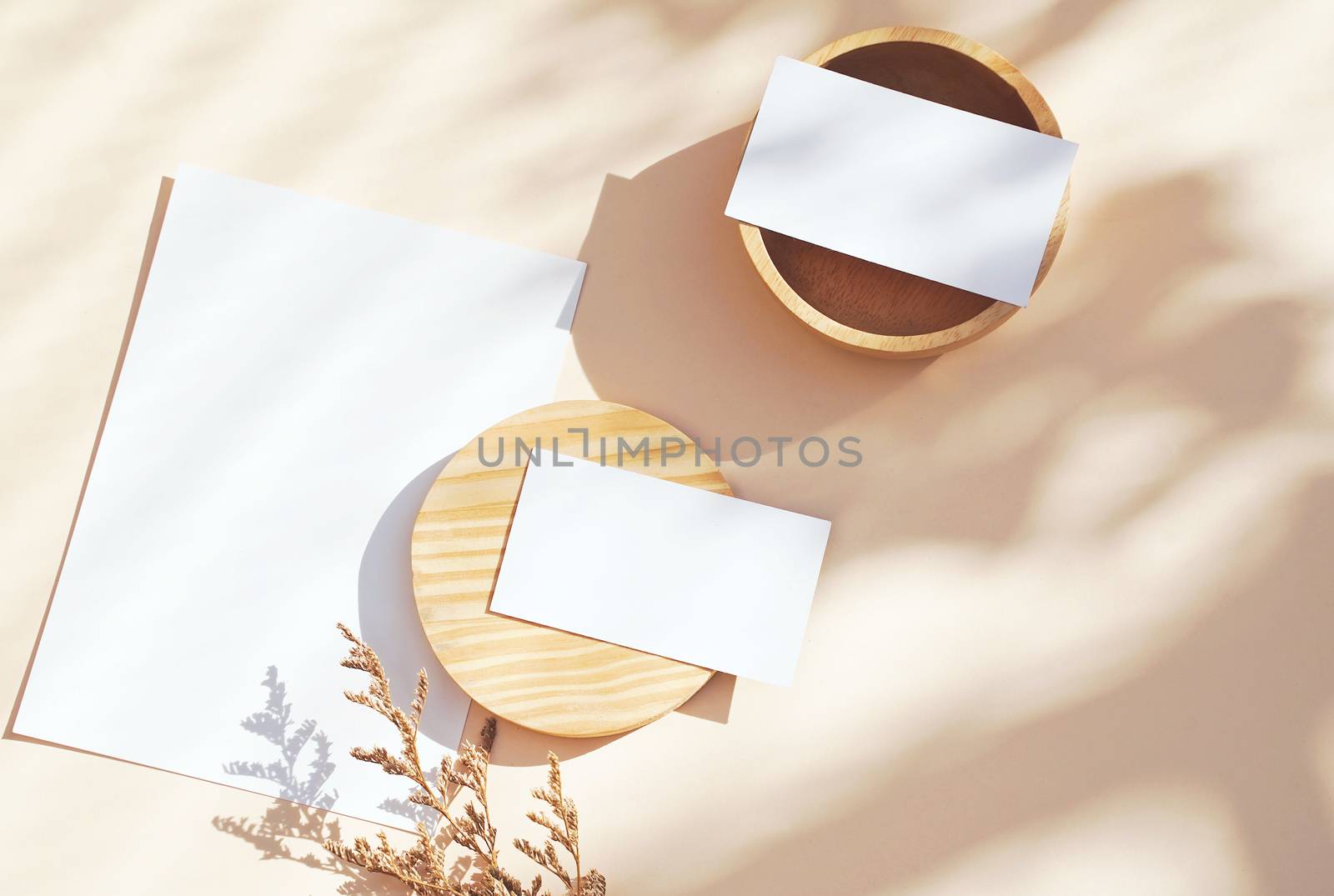 Flat lay of branding identity business name card on yellow background with flower and wooden container, light and shadow shape leaves, minimal concept for design