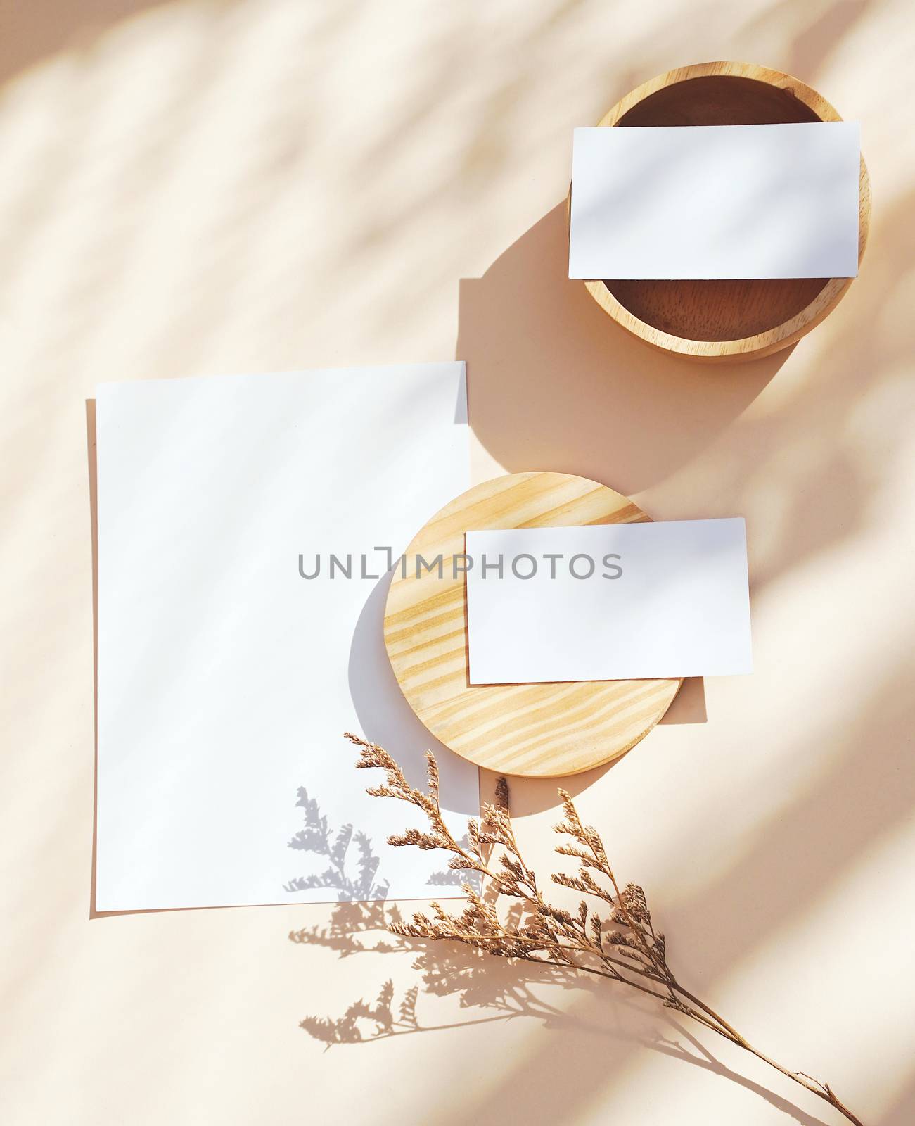 Flat lay of branding identity business name card on yellow background with flower and wooden container, light and shadow shape, minimal concept for design