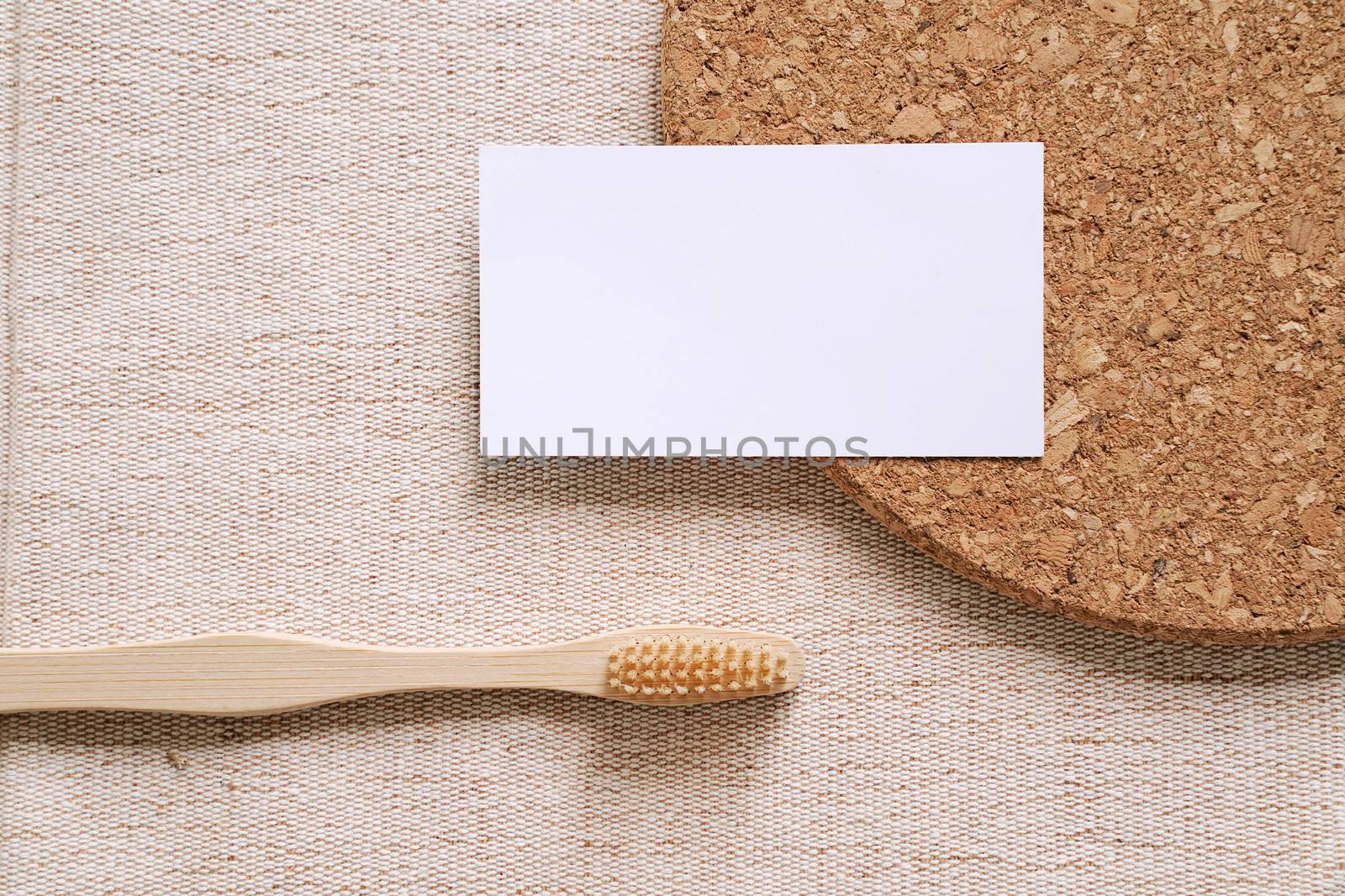 Flat lay branding identity business name card with sustainable products, bamboo toothbrush on fabric background, minimal concept for design