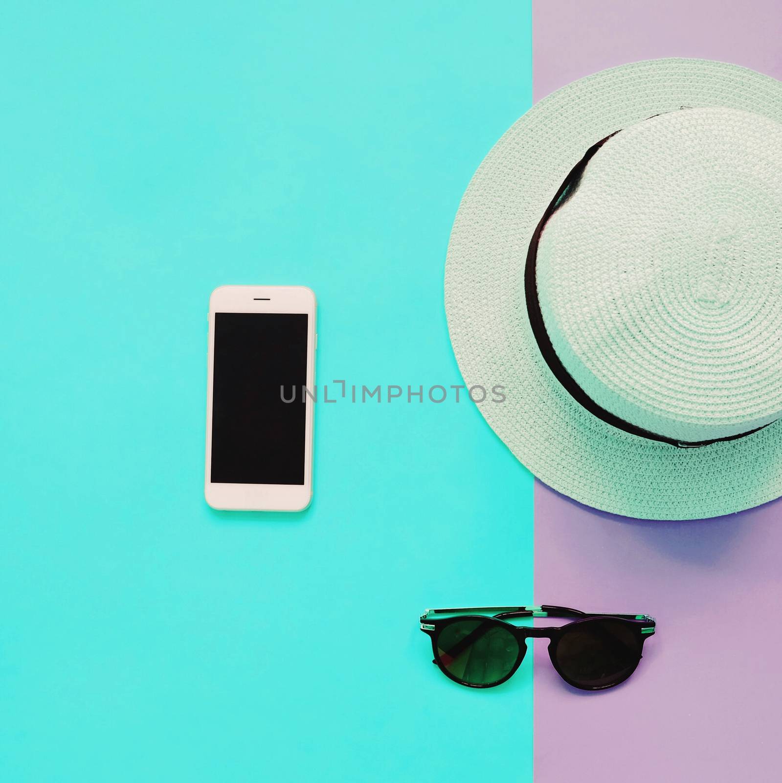 Flat lay fashion of smart phone, panama hat and sunglasses on pa by nuchylee