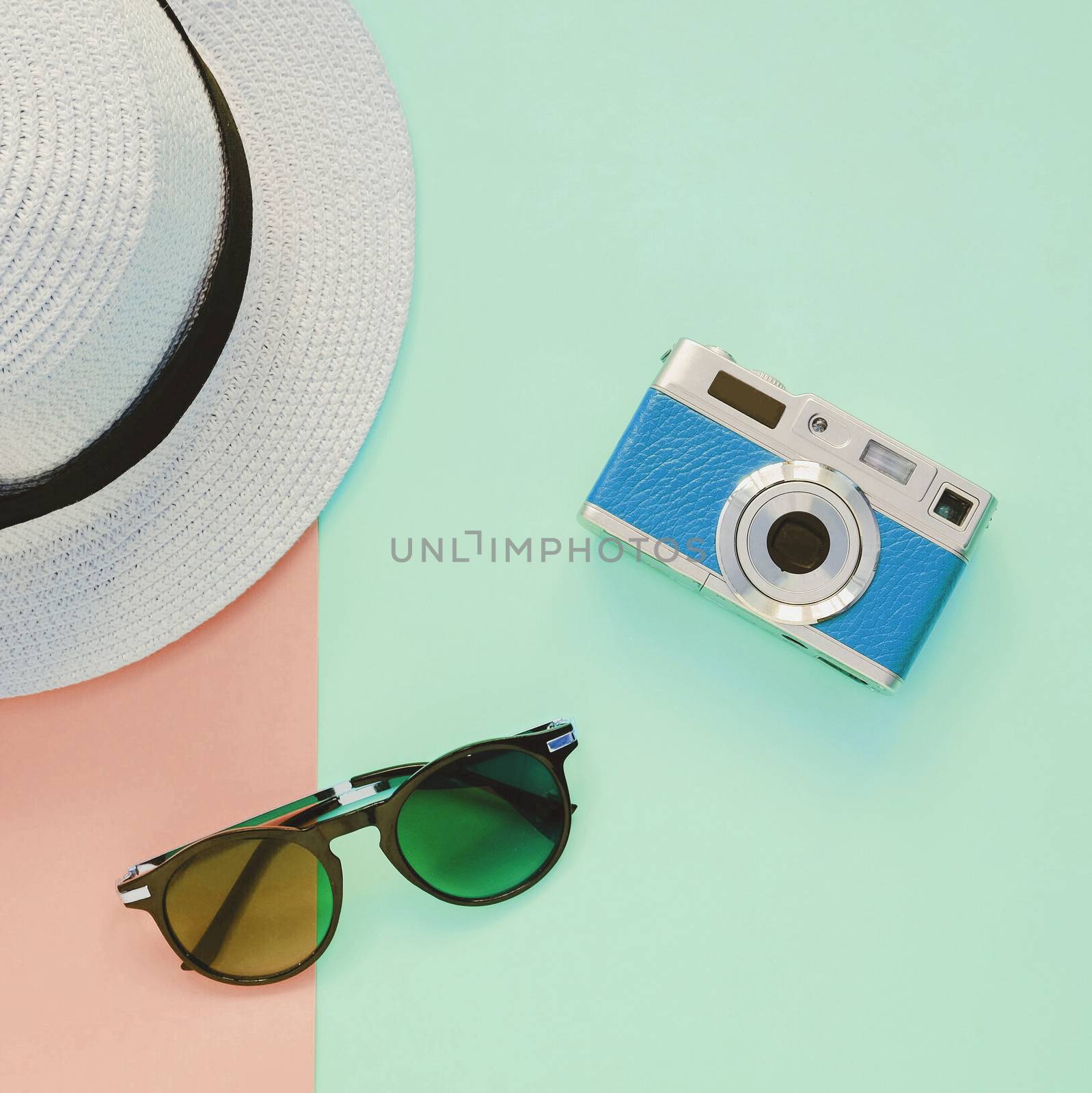 Creative Flat lay fashion style with camera, sunglasses and panama hat on pastel color background
