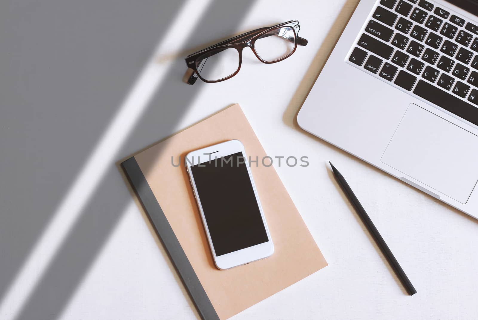 Flat lay photo of office desk with laptop, smartphone, eyeglasse by nuchylee