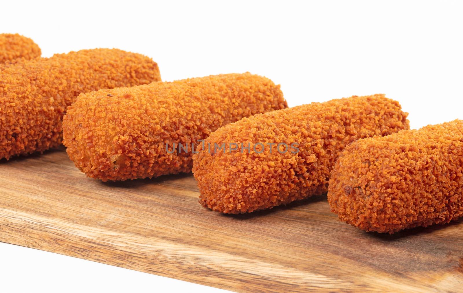 Brown crusty dutch kroketten on a serving tray, selective focus, isolated