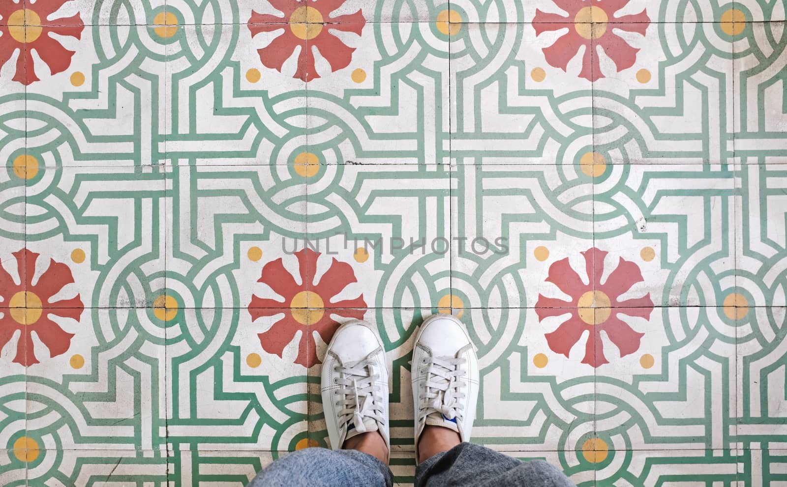 Top view selfie of feet in sneakers shoes on the vintage seamless floor background with copy space