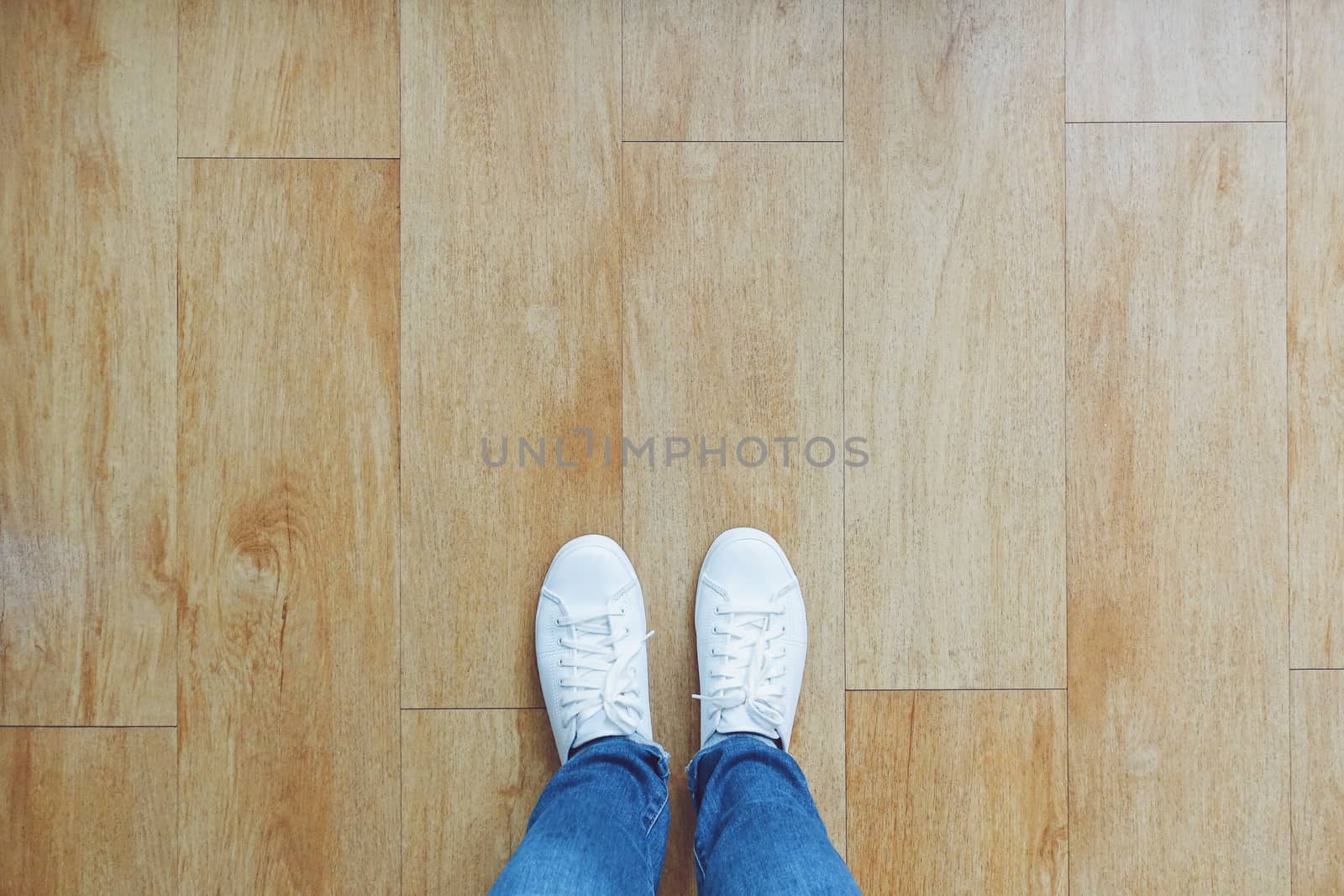 Selfie of feet in fashion sneakers on wooden floor background, t by nuchylee