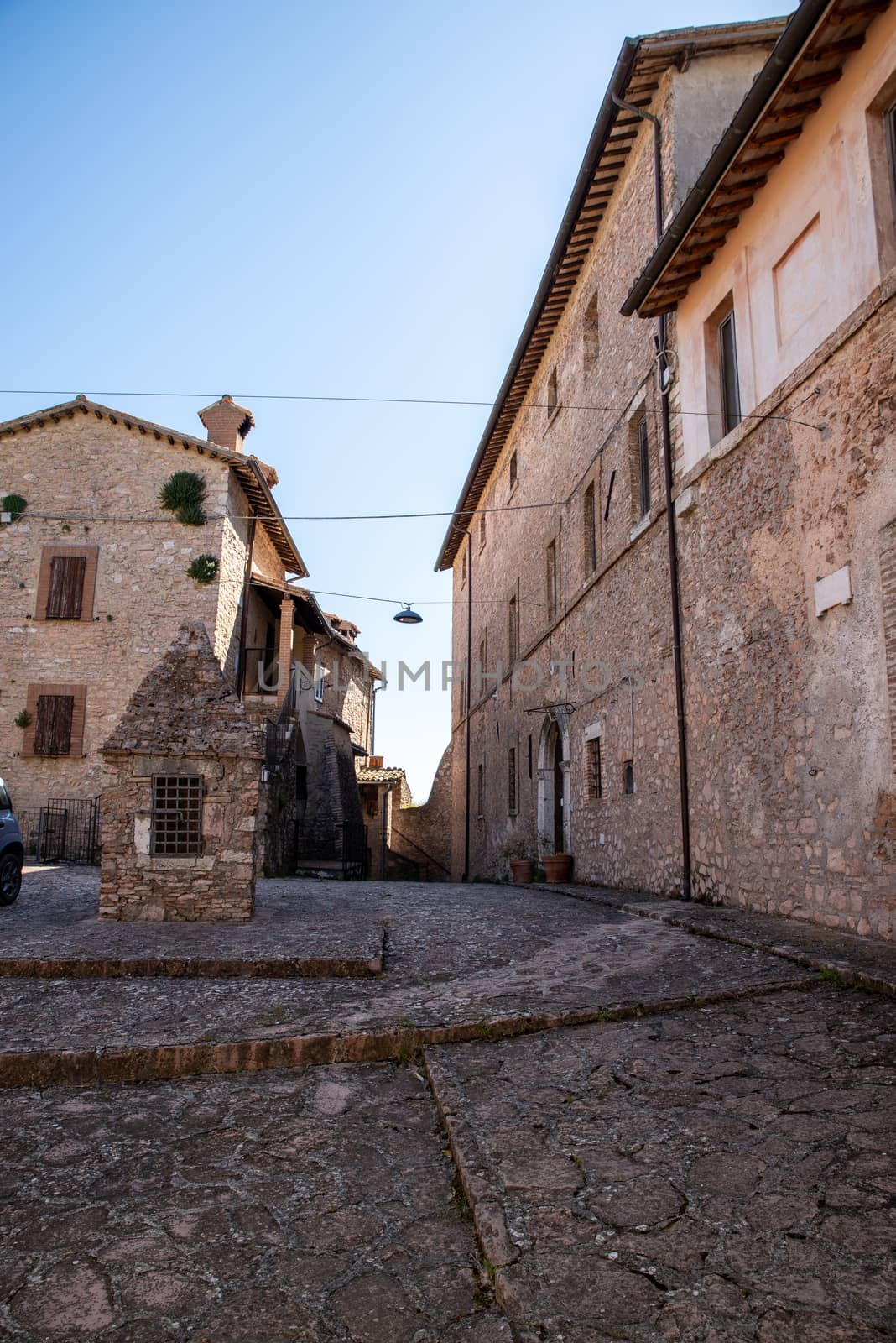 macerino,italy june 02 2020 :lower square of the village of macerino with the old well and the largest palace in the country