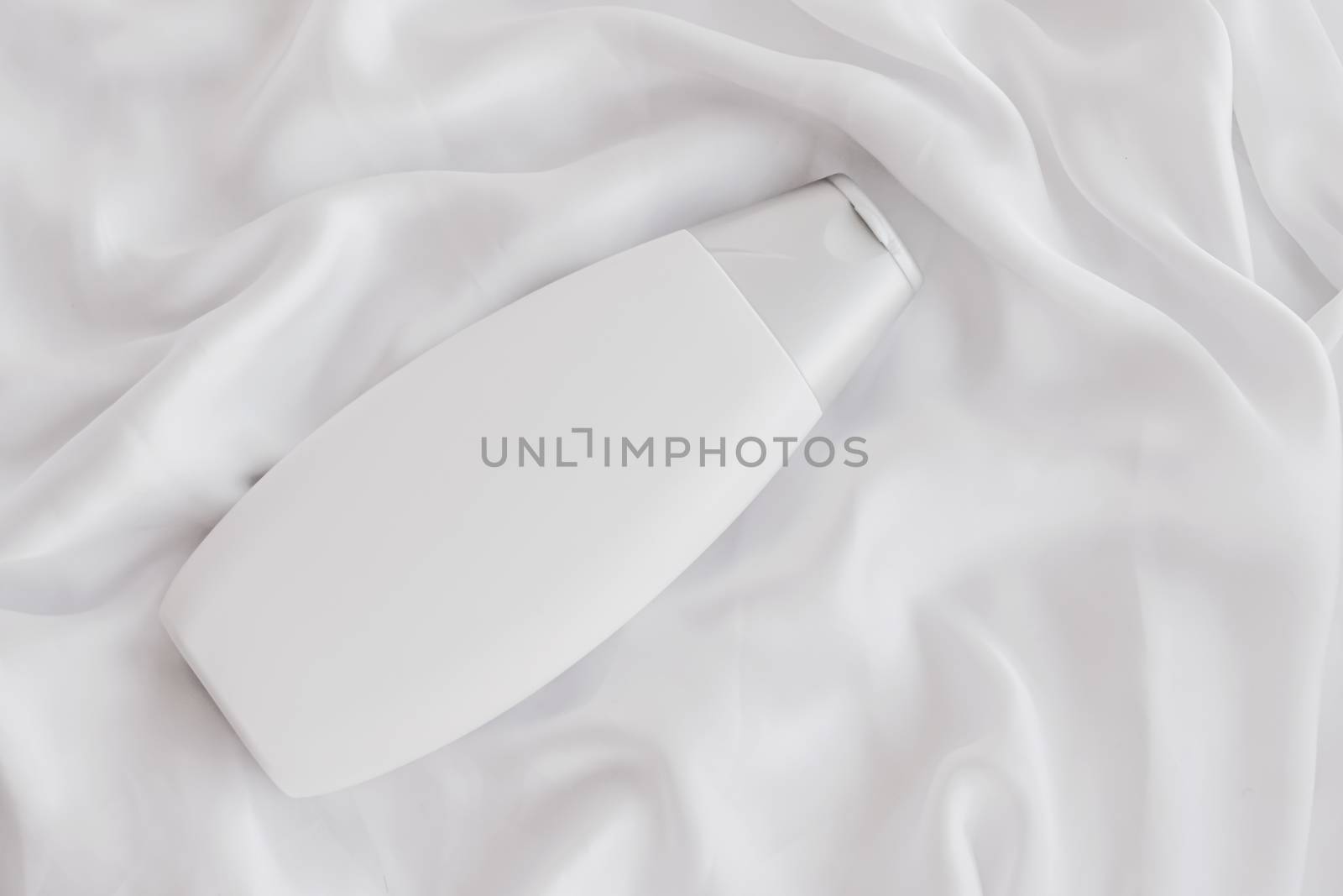 Blank label cosmetic container bottle as product mockup on white silk background by Anneleven