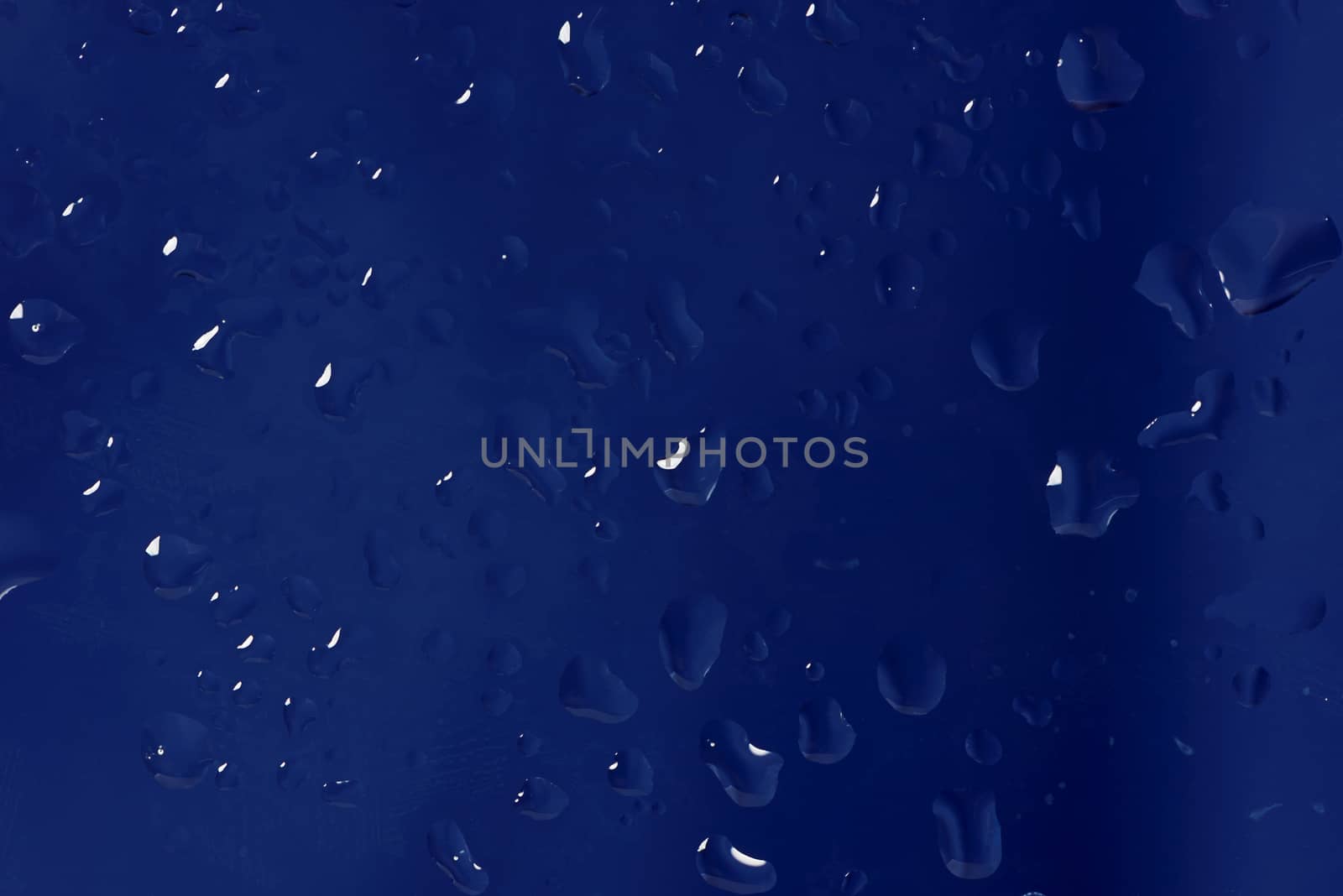 Blue abstract background made drops of water on a glass